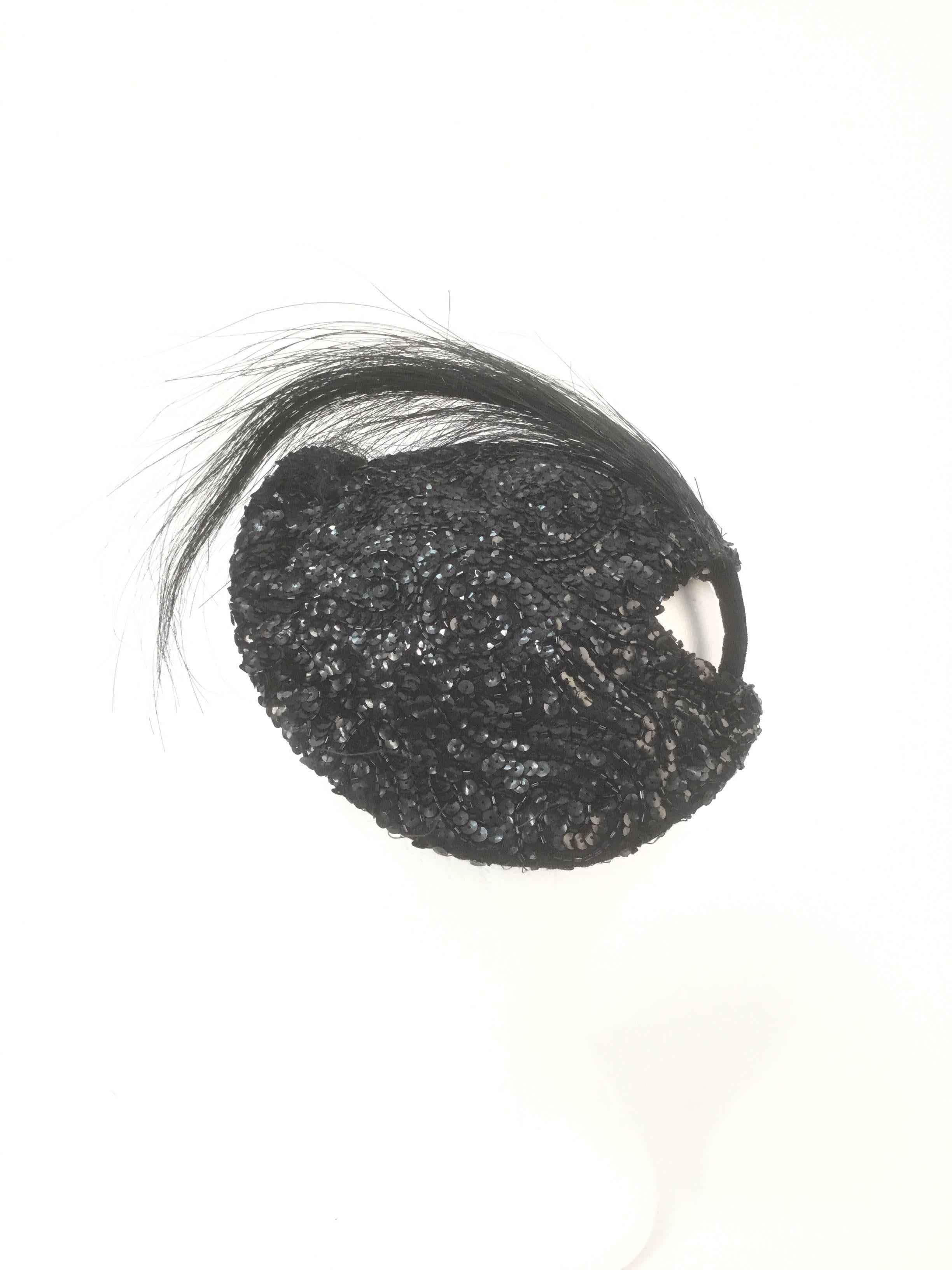 Stunning and glistening, this gorgeous Milgrim hat is sequined and beaded in a swirl of forms. The hat features a bouquet of burn ostrich feathers affixed to the hat via a velvet base. The hat has a mesh lining with a grosgrain ribbon, and sits