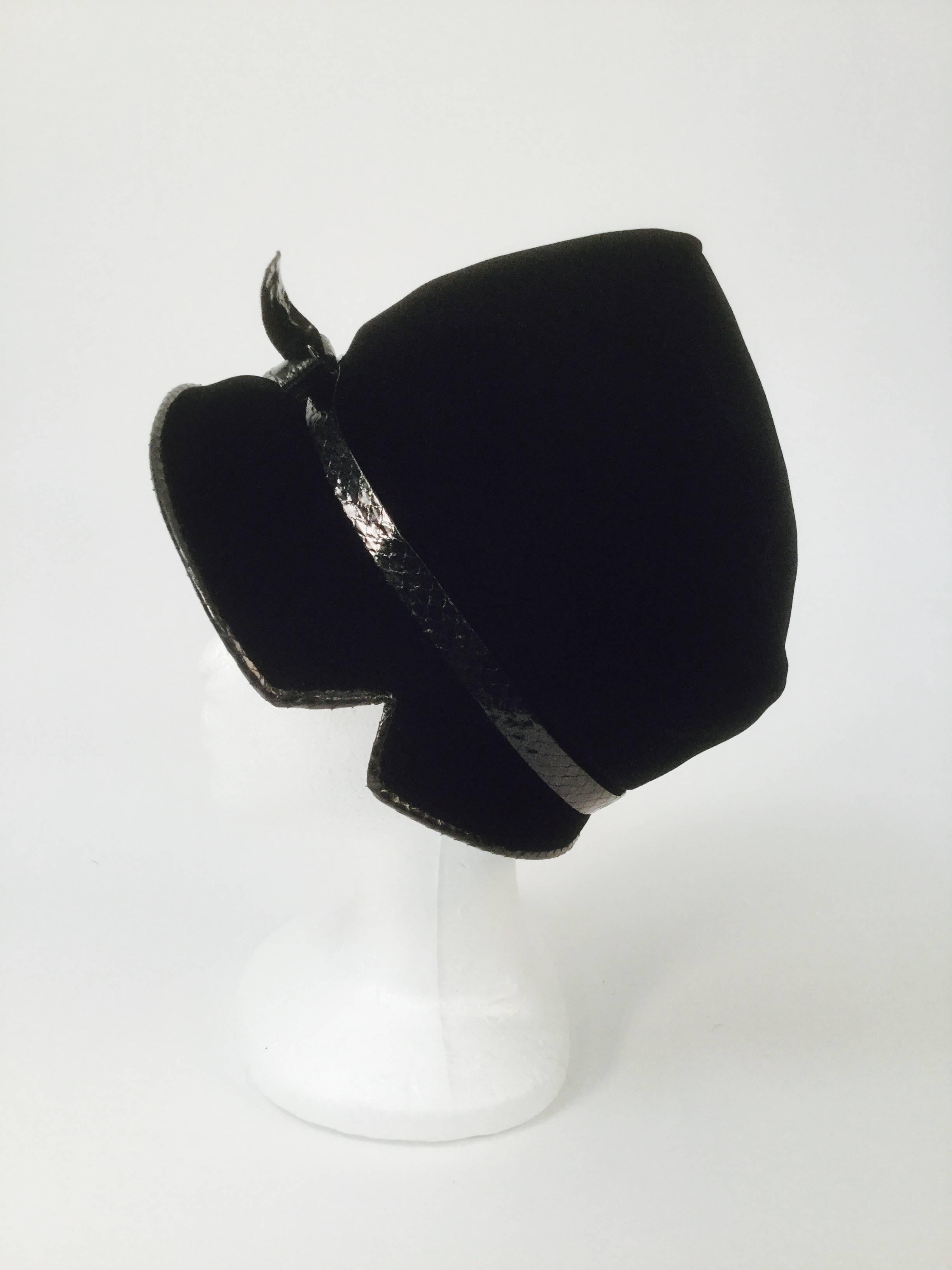 
Striking mod hat by Christian Dior for Mc Curdys of Rochester! This velvet cloche - bonnet hat has a flat top, and a wide front brim that tapers towards the back. The tapering brim features two notches -one on each side- just above the temple. The