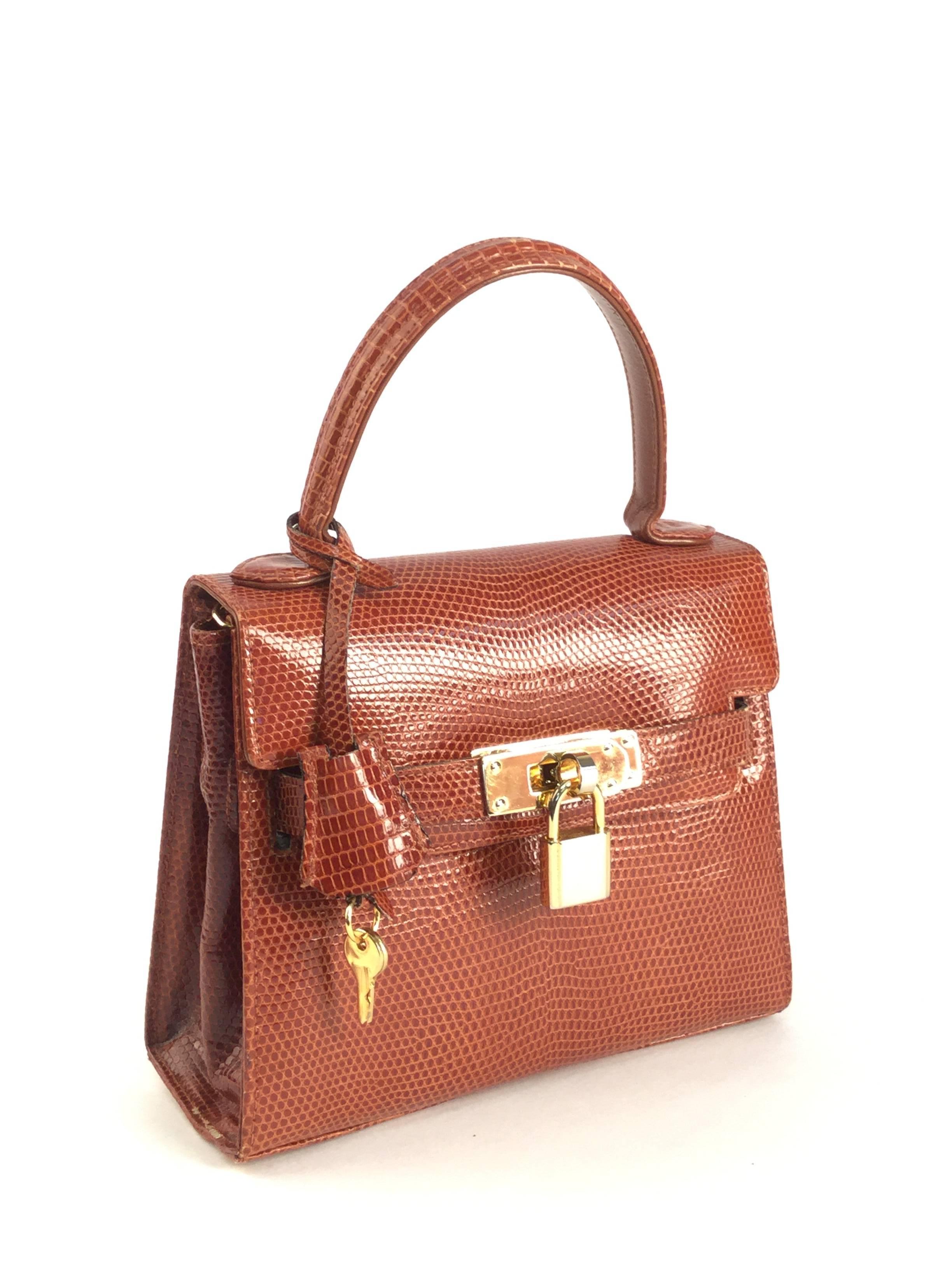 Vintage Finesse la Modele Top Handle Double Strap and Lock Lizard Leather Handbag. Absolutely gorgeous vintage handbag by Finesse la Modele! This handbag has a top handle, two straps that wrap around the flap to secure the circular twist closure,