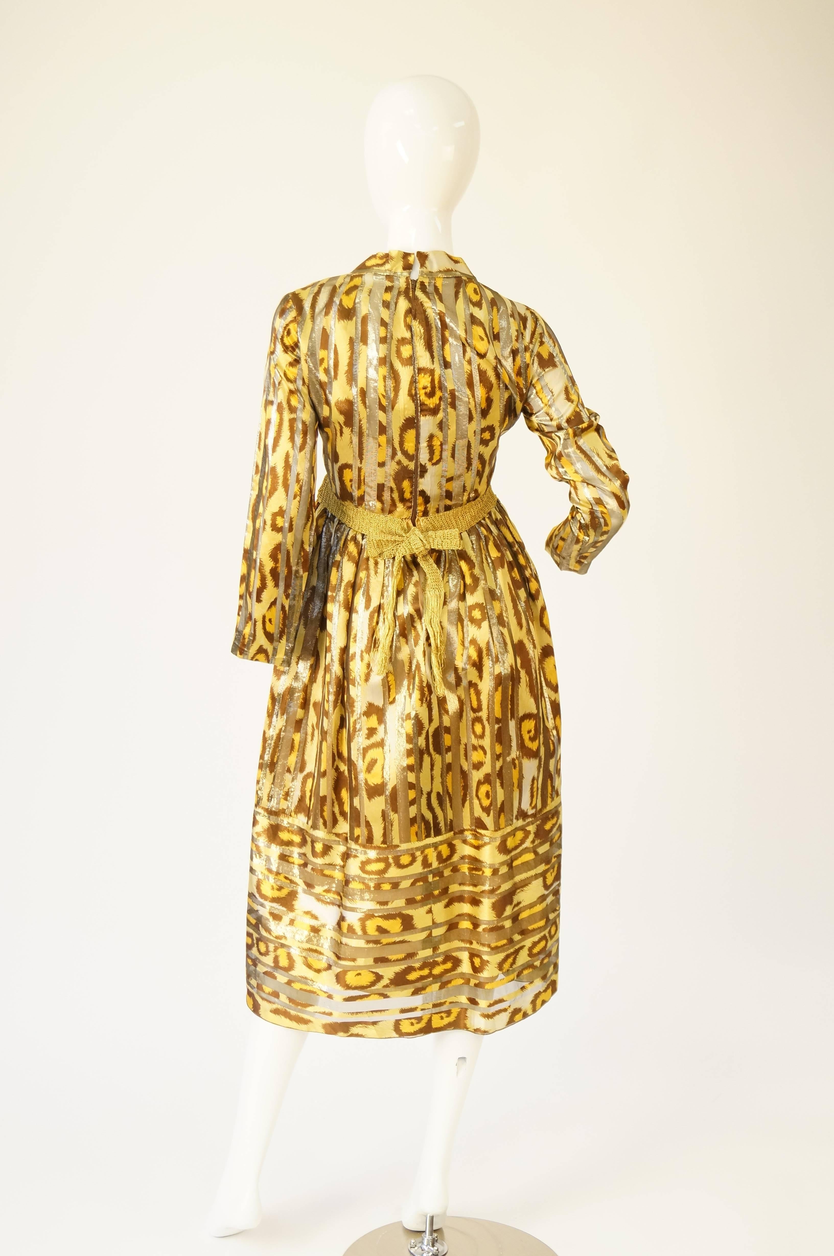 
Fantastice and fun and vintage midi length evening dress!

This long sleeve dress features a V-neck emphasized by gold vertical stripes, an empire waist accented by trending Macrmé gold bow belt that ties in the back, and a midi skirt with