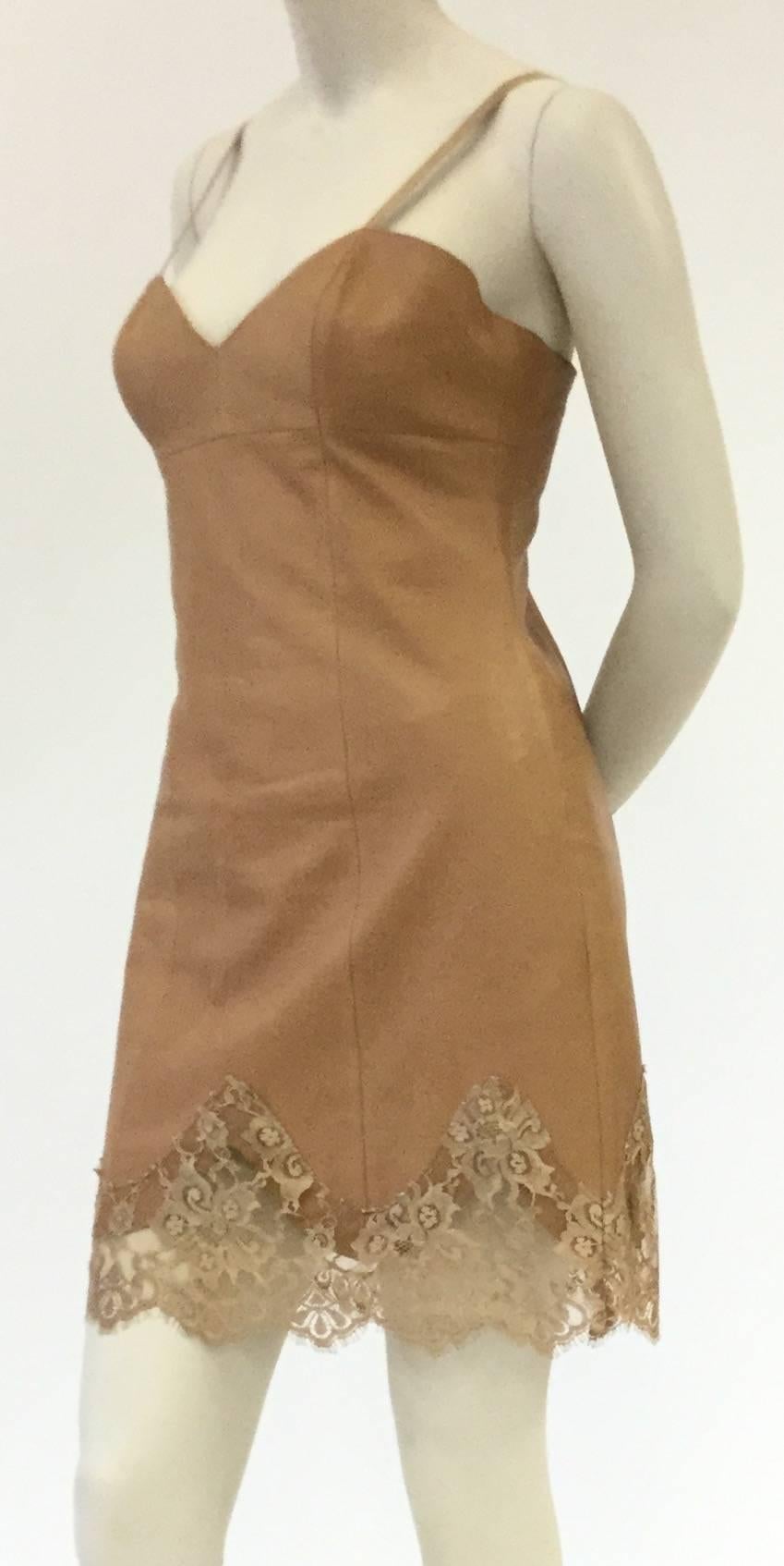 A sweet and edgy slip dress by Michael Hoban North Beach Leather. This minidress features a sweetheart neckline with thin straps, and princess seams that emphasize the wearer's waistline. The dress has a wide scalloped leather hem under a scalloped
