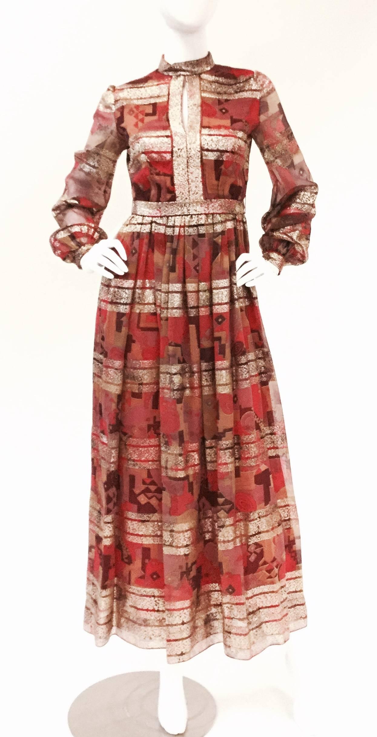 
Gorgeous geometric print gown with  by Elinor Simmons for Malcolm Starr. This dress has a high collar with keyhole neckline, natural waistline ankle-length skirt, and voluminous shirtwaist sleeve. The geometric print features horizontal stripes
