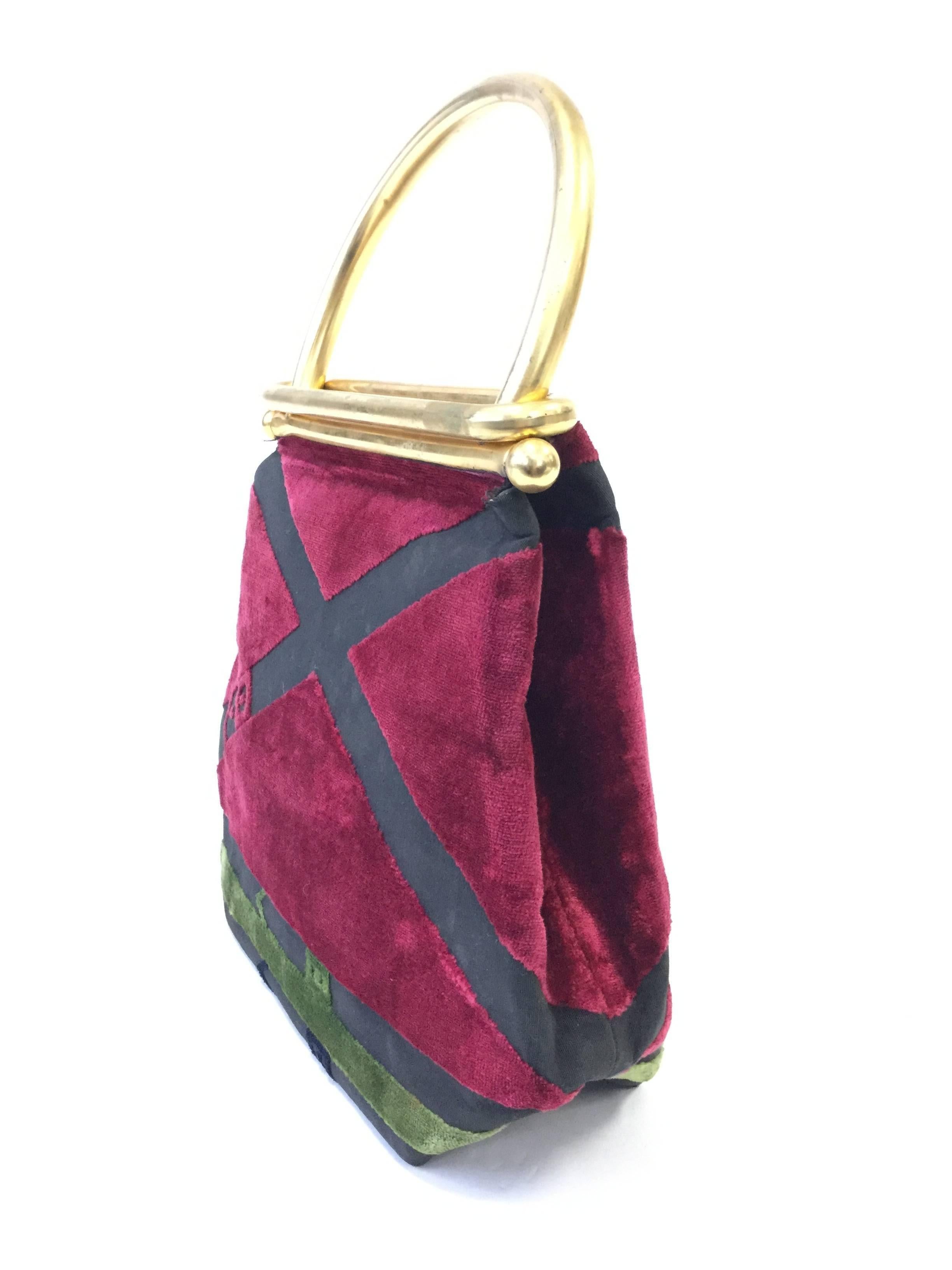 
Fun and funky Roberta di Camerino handbag! This a-frame handbag features an ingenious gold tone a sliding lock hardware handle and a velvet body. The body of the purse is cranberry red and sage green with belt designs crossing the velvet. The