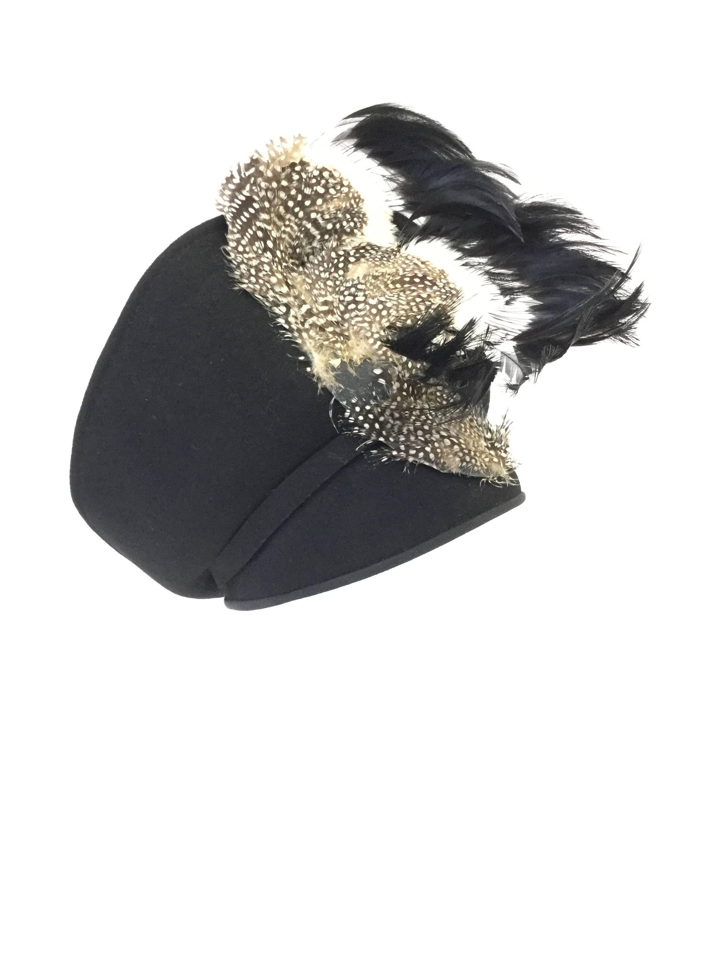 
Absolutely striking hat by Jack McConnell boutique! This sculptural hat features a black felt base consisting of a rounded base that fits snuggly on the wearer's head, and a tiara-like brim. The upturned brim is richly ornamented with guinea fowl