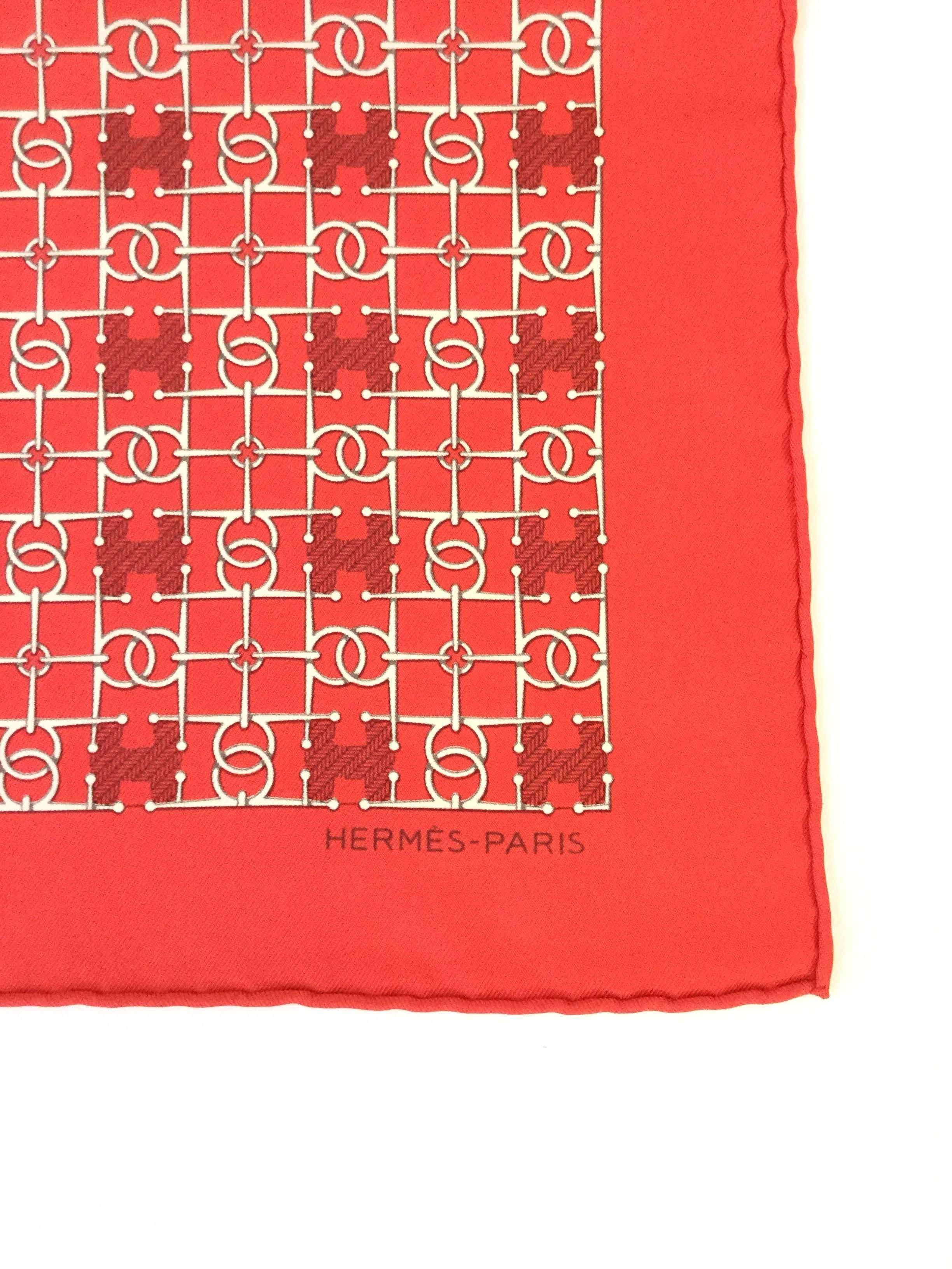 
Understated and elegant silk scarf by Hermès. The scarf feature a repetitive loose ring and Hermès 