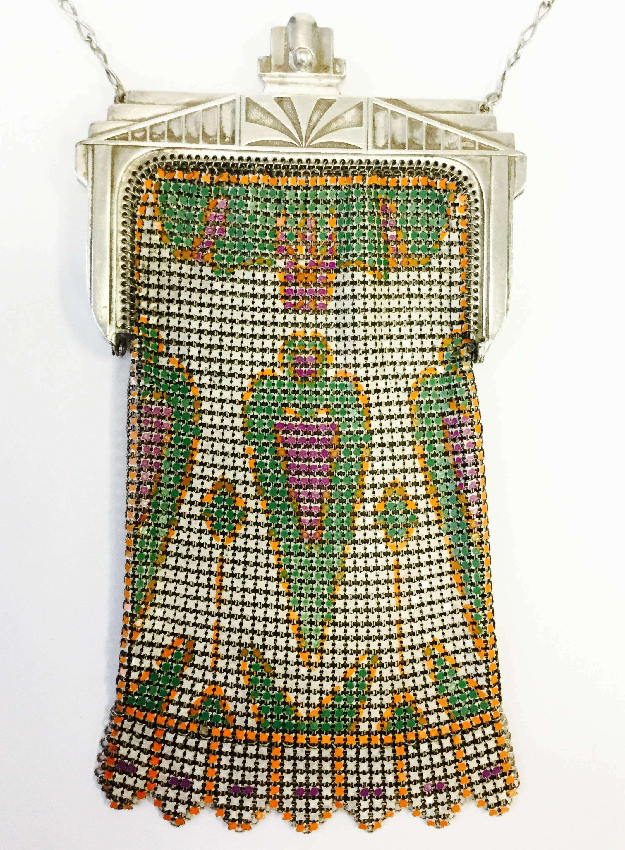 
Fantastic 1920s mesh evening purse! This chainmail purse has a pressed metal art deco closure with a sunburst design, and the body features a wonderfully preserved enamel print. The symmetrical peach pink, parrot green, and tangerine orange