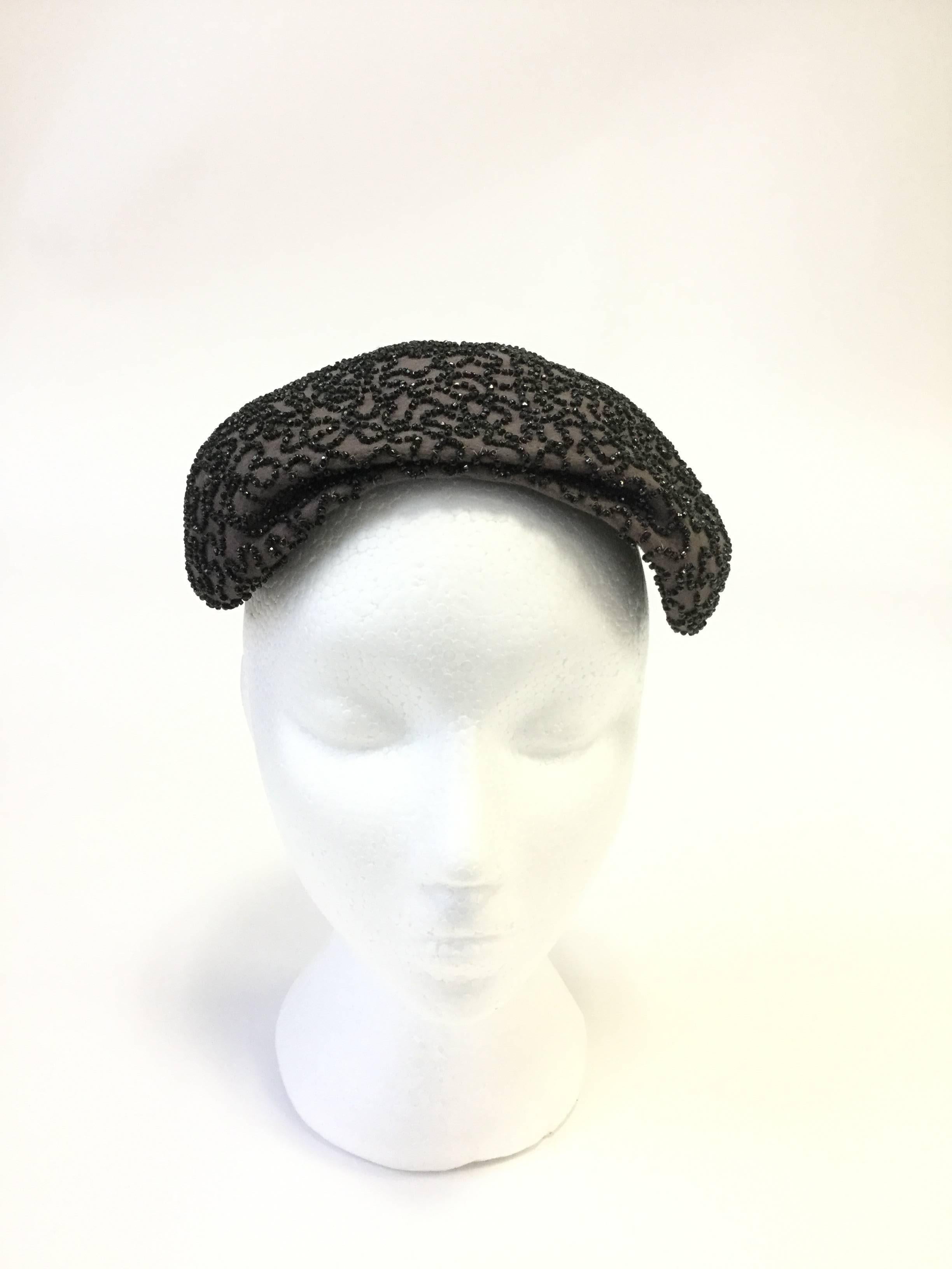 
Striking hand beaded hat by The Fair! This elegant capulet evening hat curves gently around the wearers head, the front slouching slightly in a relaxed brim. The cap is fully beaded in an undulating wave pattern that brings to mind the organic