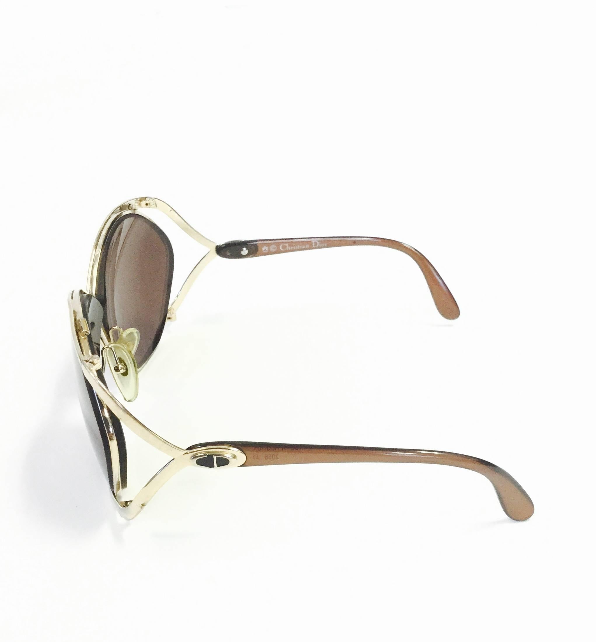 
Iconic 1980s Dior butterfly sunglasses! These glamorous, feminine sunglasses showcase Dior's famous butterfly design. The chocolate brown and gold-tone frames gently wrap around the oversized lenses. The letters "CD," for Christian Dior,