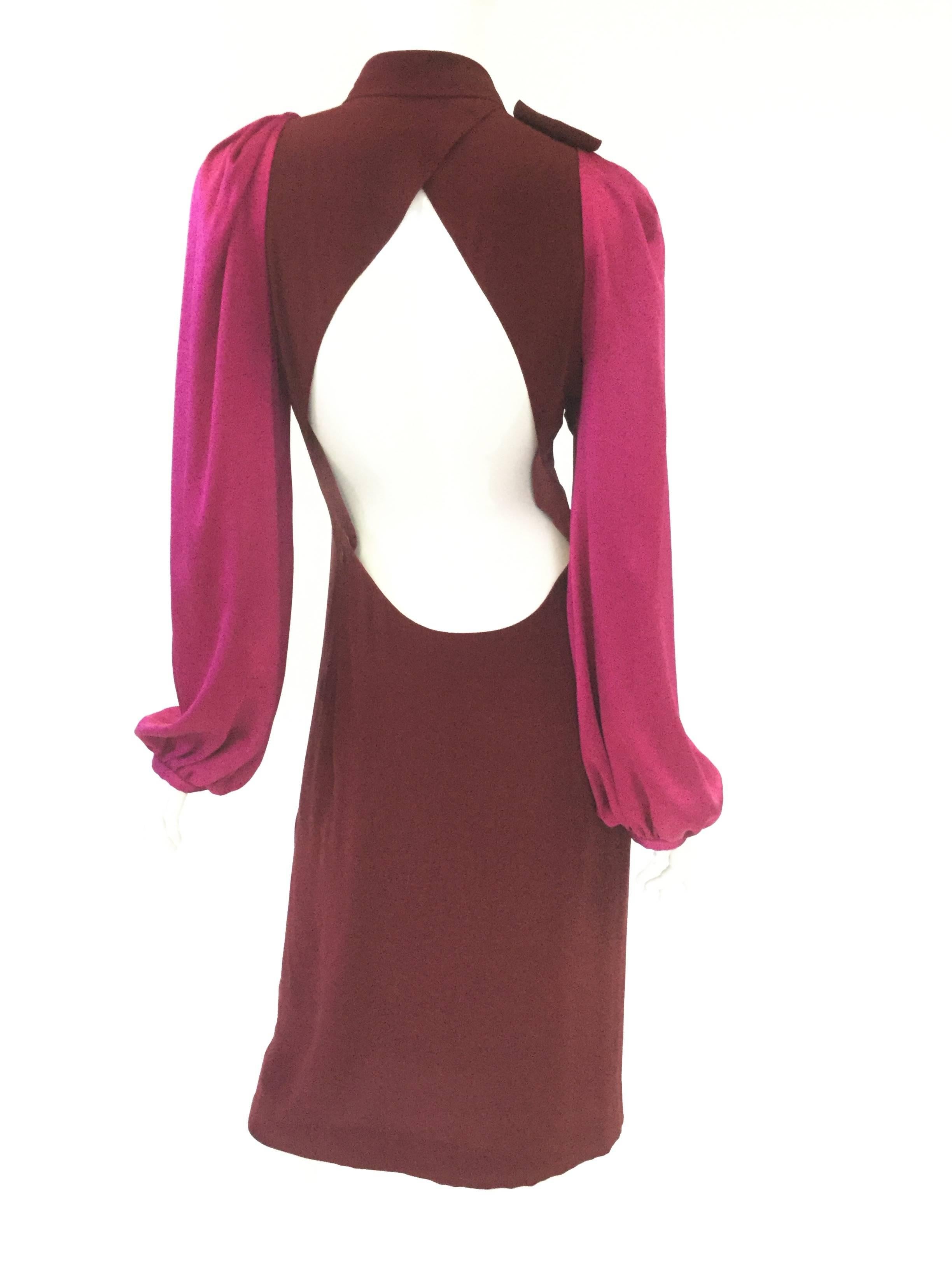 Stunning cerise and maroon dress by Sonia Rykiel! The dress is primarily a red-brown maroon with billowing pink-fuchsia bishop sleeves. The keyhole neckline of the dress is accented by a relaxed collar bow. The teardrop-shaped scoop back is