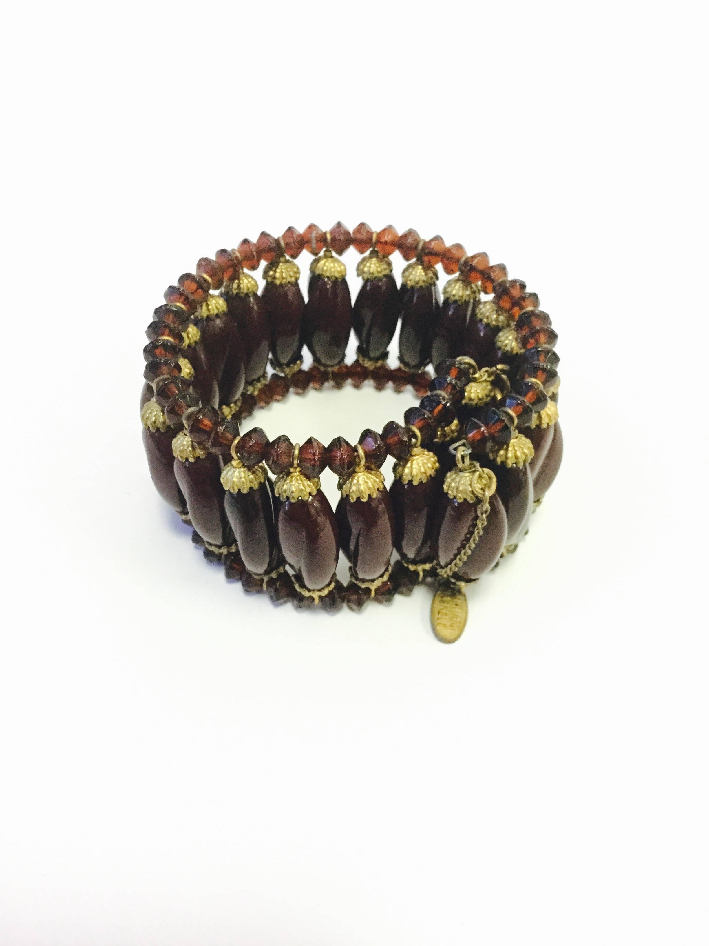 Fun and funky Miriam Haskell choker and bracelet duo! This matching necklace and bracelet are essentially made in the same manner. Both pieces consist of a swirled oval opaque maroon glass bead held in place by a floral clasp at the top and bottom,