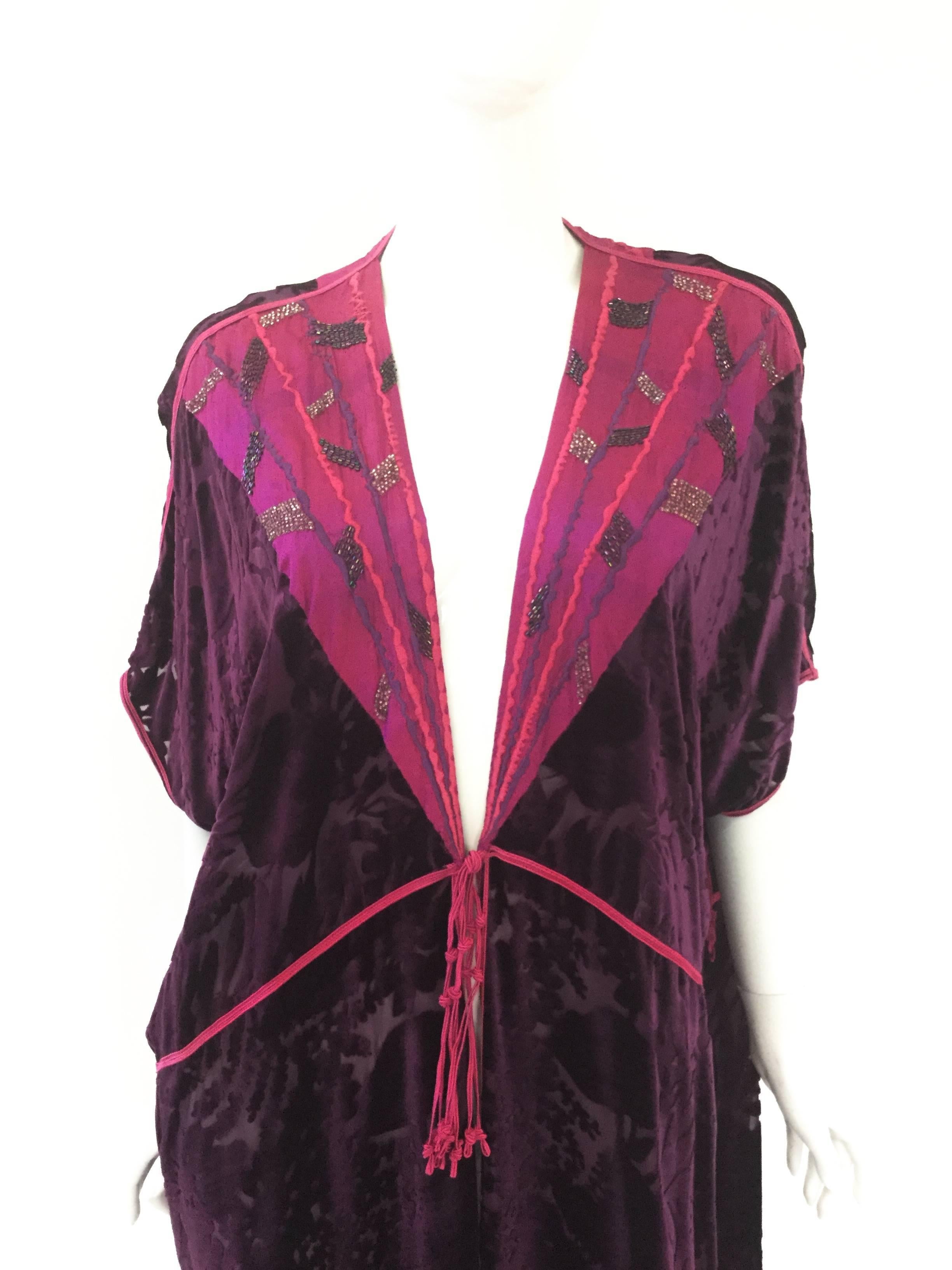 
Gorgeous Thea Porter Couture hostess gown. The gown is primarily composed of purple devoré burnout velvet in a floral motif. The gorgeous magenta fuchsia silk collar features pink and purple stripes running to the center of the gown. Purple and