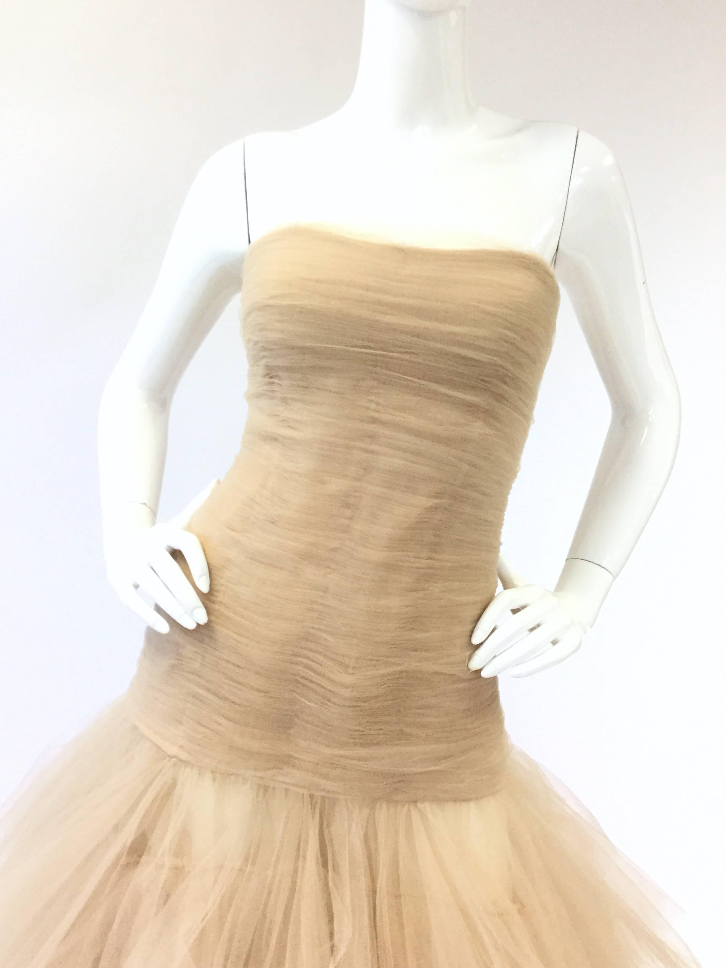 

This fantastic gown by Oscar de la Renta gown features a horizontally pleated extended bodice with a slight sweetheart neckline. The mini pleats delicately curve to the structured, boned bodice. The skirt, with its many angular tiers, billows out
