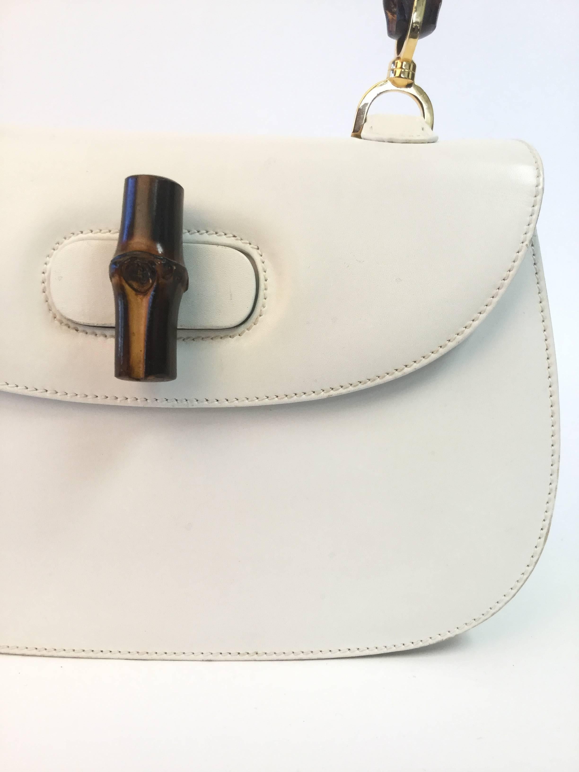 Rare and Iconic!

This gorgeous 1960's handbag in one of Gucci's most famous designs! The white leather purse has a saddlebag construction with a flap that lays over the front of the purse. The espresso bamboo handle of the purse curves gently from