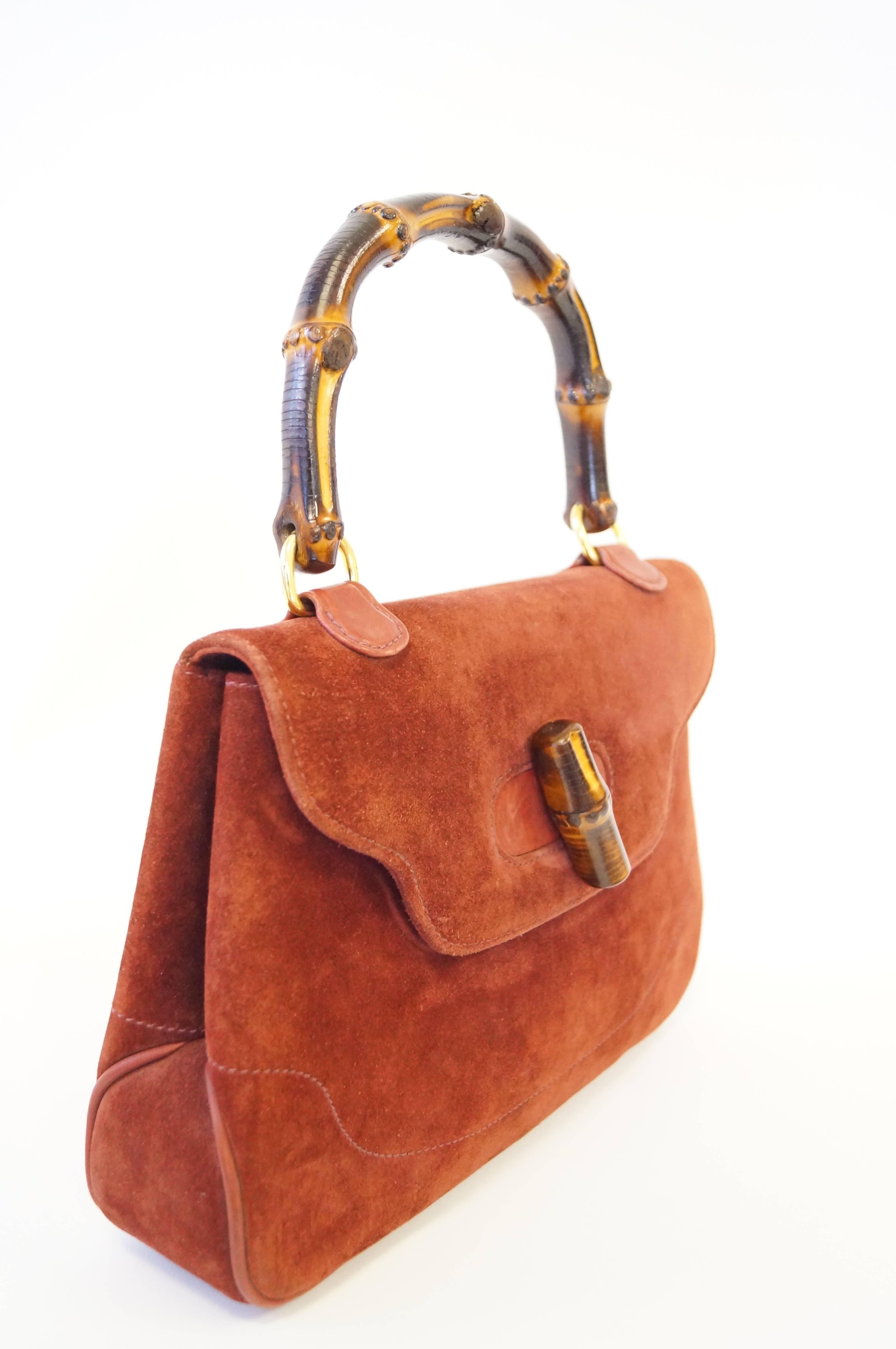 Rare and Iconic!

This gorgeous 1970's handbag in one of Gucci's most famous designs! The rust colored suede purse has a saddlebag construction with a flap that lays over the front of the purse. The espresso bamboo handle of the purse curves gently