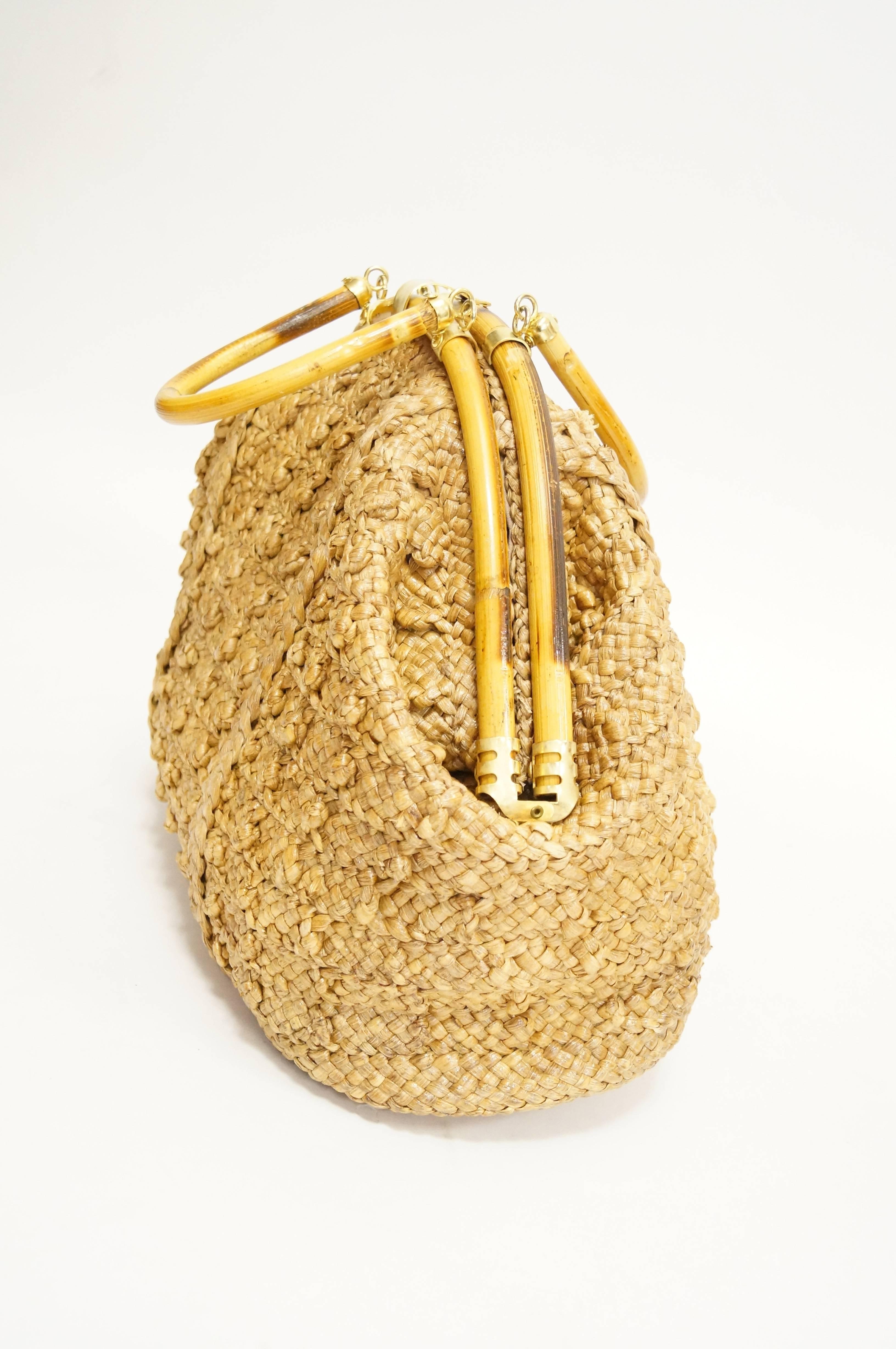 Sculptural hand woven bag by Delill! The bag is composed of woven grass carefully treated with resin, giving it a glossy shine and adding to its durability. The grass is woven in a criss-cross pattern, with accent knots and vertical stitching