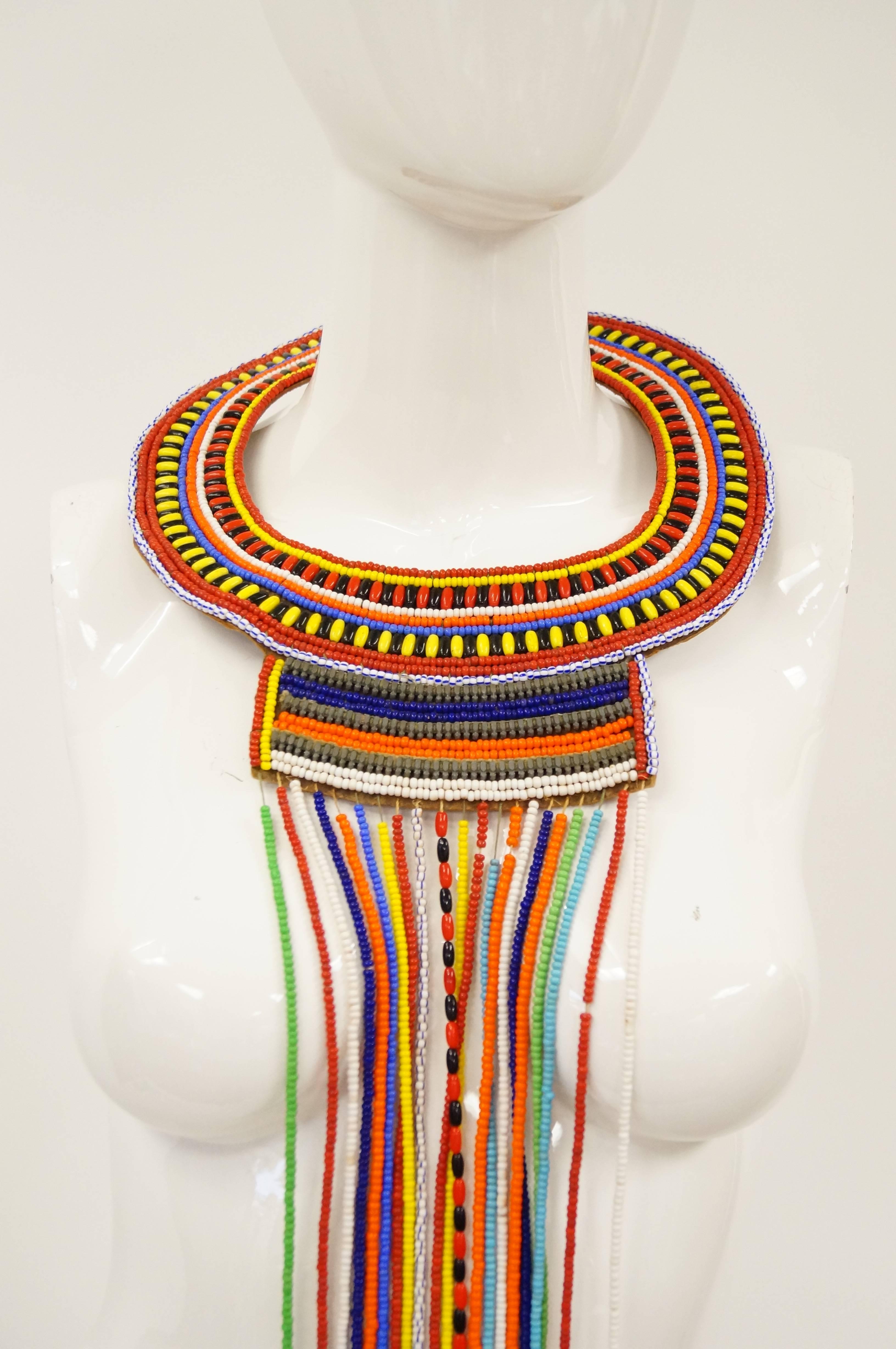 Statement tribal beaded neck piece. Multi colored glass beads on a leather backer. 

18" Neck
41" Length