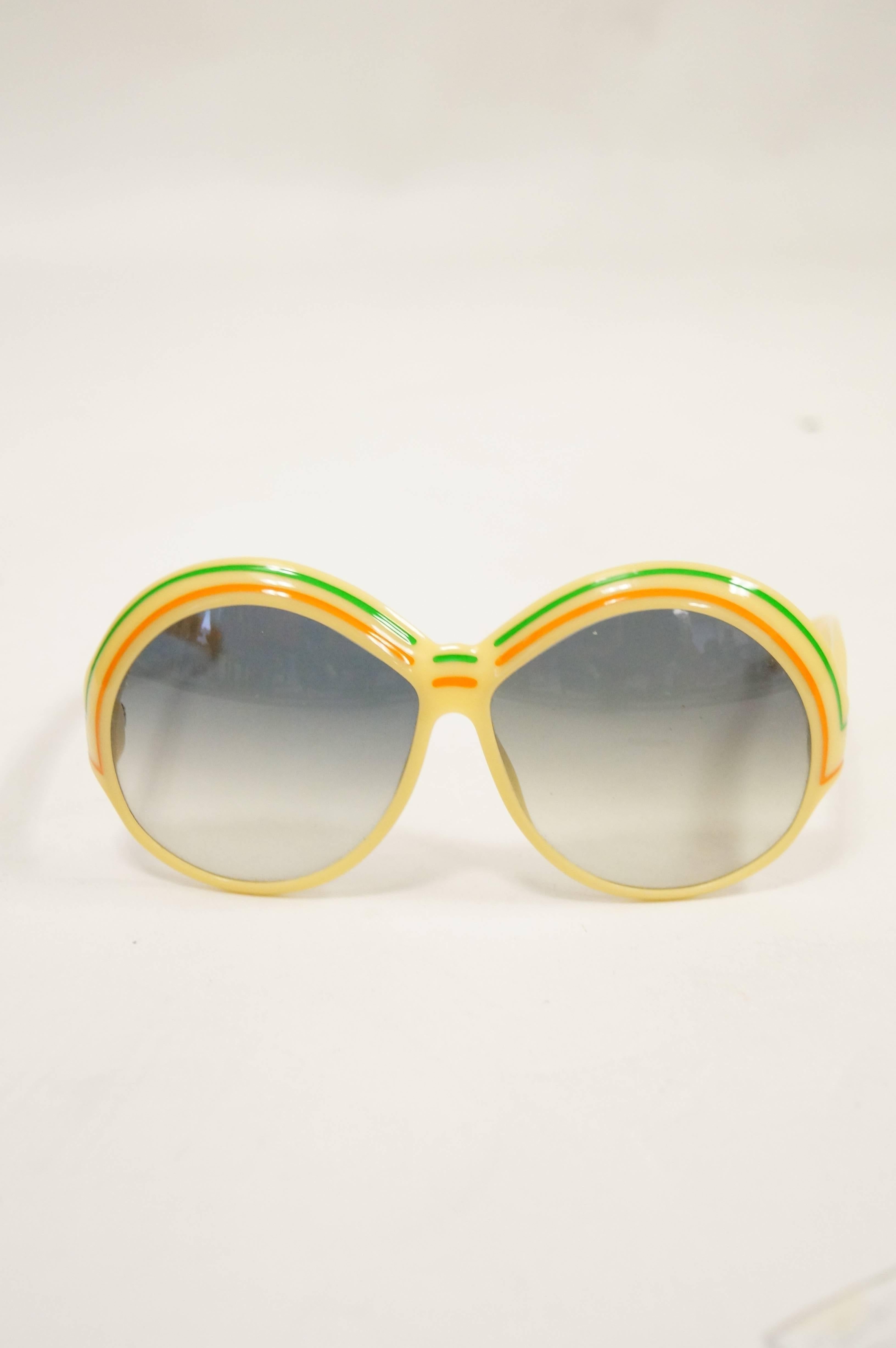So vintage! So fabulous! Yellow frames with wide, circular lenses in a green ombre tone. Brow decorated with orange and green lines. Made in Germany.

Frame Width- 6
