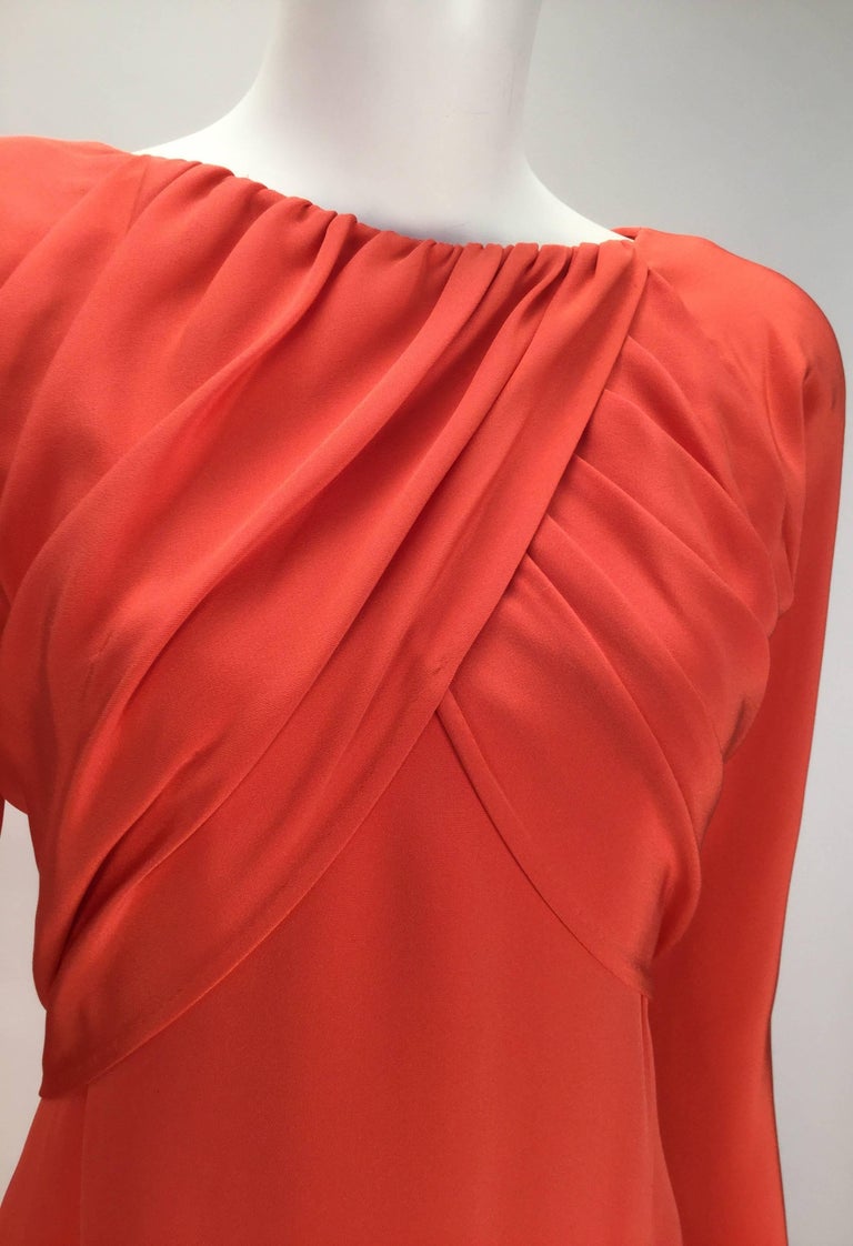 Simply sublime 1970's Halston red silk long sleeve evening dress. Scoop front neckline that falls into a V shape at center back. Shoulder pads. Draped at bust, with gathering at front neckline. Gathering where the zipper is at center back, and only