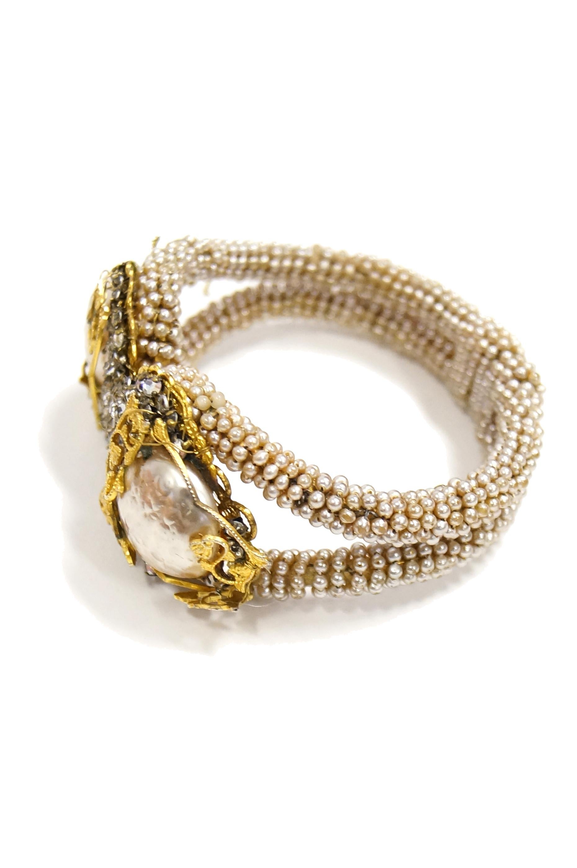 Beautiful Seed pearl encrusted clamper bracelet with two large baroque styled accents surrounded with rhinestones and botanical gilt design. 

Fits up to a 6.5 -  7 inch wrist 
50 grams