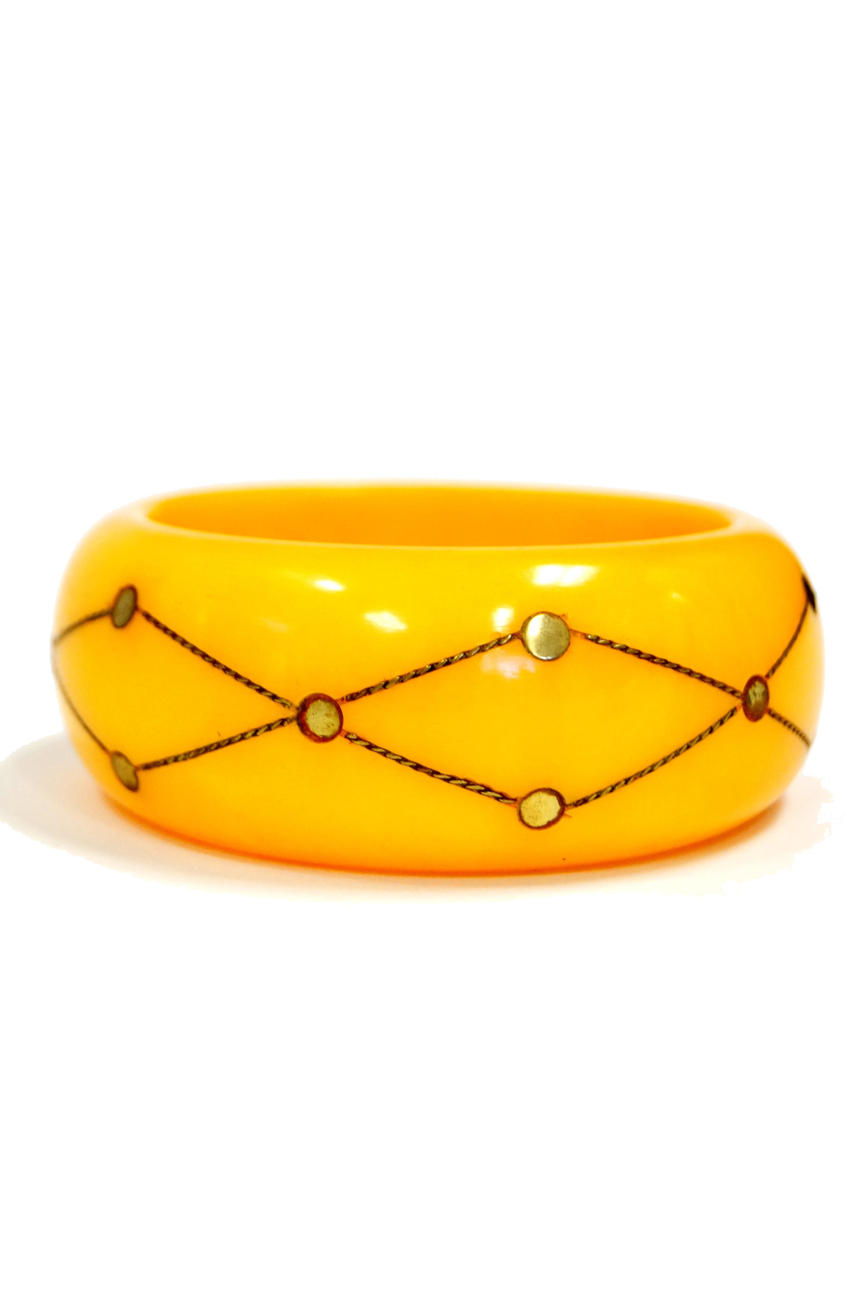 Fantastic and Highly Collectible. 
Art Deco butterscotch colored bakelite bangle has metal chain and dot injection of brass.


8