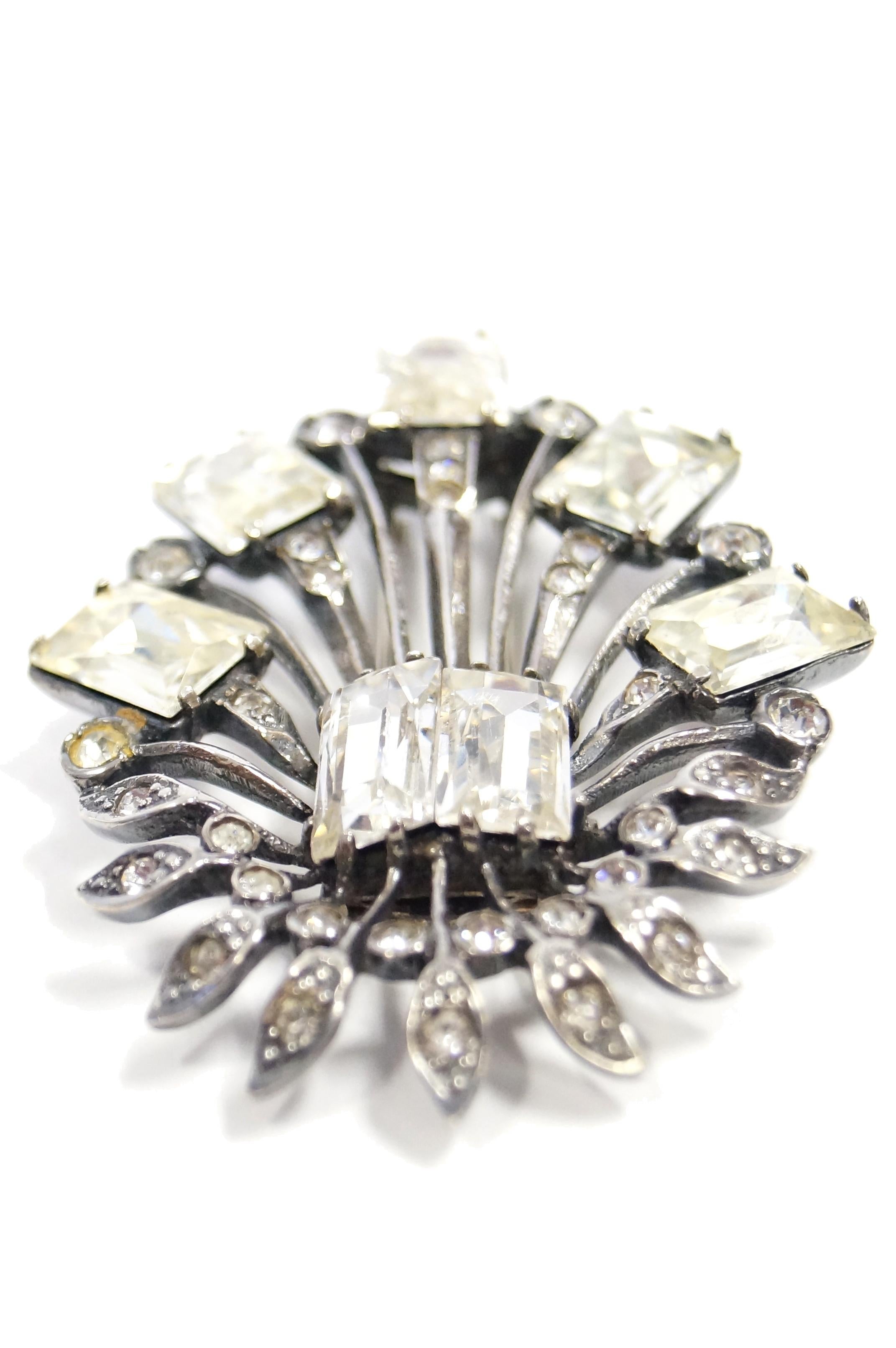 Elegant oversized sterling and rhinestone brooch by Eisenberg. The brooch consists of two large emerald cut clear rhinestones from which sprout various sterling stems. The longer stems are adorned with small round multifaceted rhinestones and are