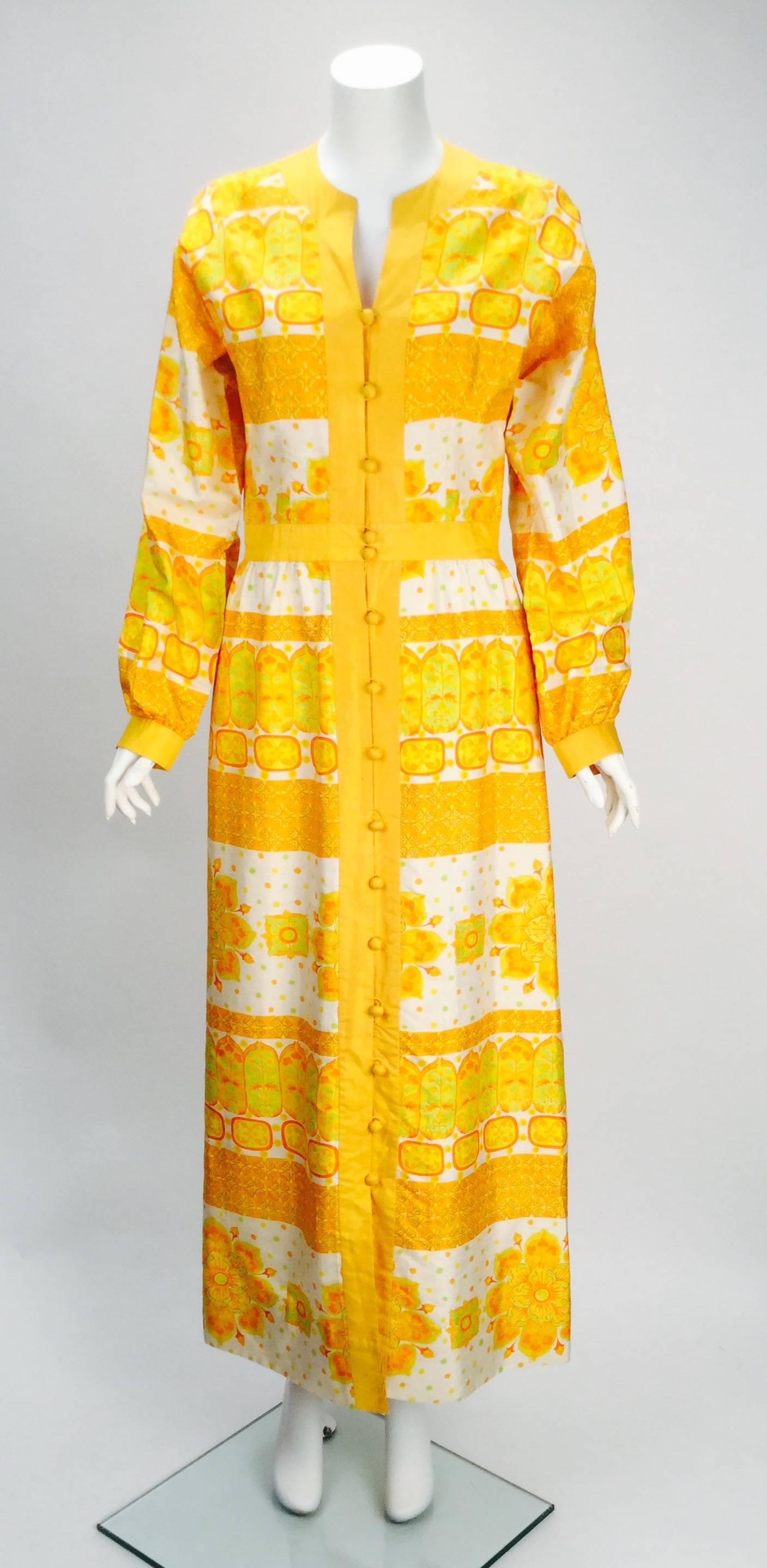 Extremely rare and absolutely beautiful 1980's Jim Thompson Thai silk dress. Fully lined in silk this fabulous yellow,orange and white print silk dress is perfect for any occasion.  The silk fabric also covers the buttons throughout the dress and