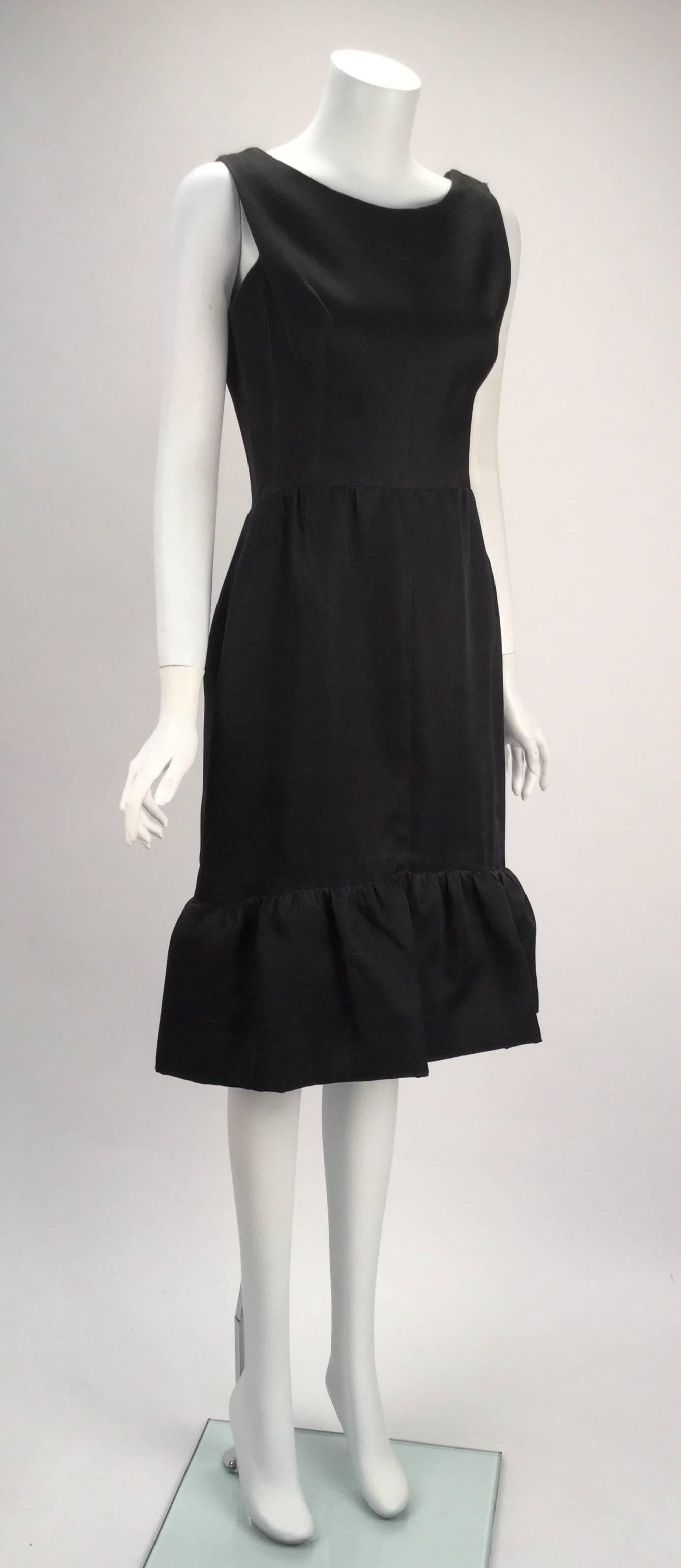 1960s Balenciaga black silk couture cocktail dress. Sleeveless with large ruffle hem. The dress fastens with a side zipper and hook-n-eye/ snap closure. One of the straps also fastens with hook-n-eyes.  

Modern Size 6

*All garments and
