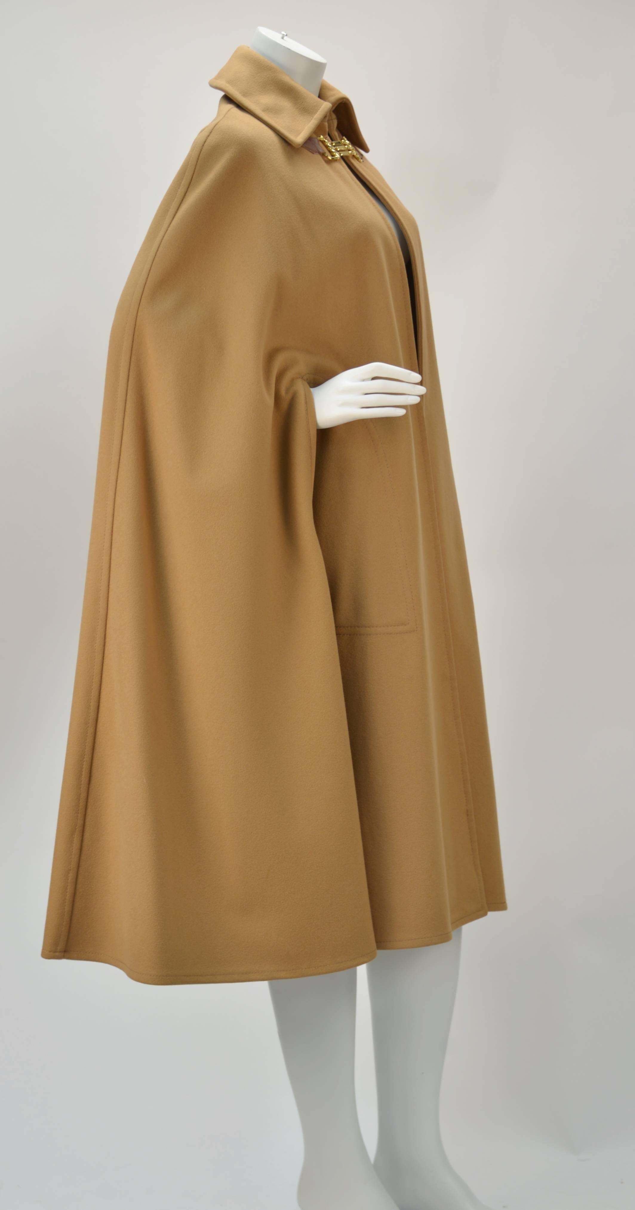 Perfect for the upcoming fall season...Celine dark tan colored wool cape with gold tone claw-like clasp that fastens at the neck. The clasp has CELINE stamped on the middle claw. Brown leather decorative straps hold the clasps into place. 

Dress