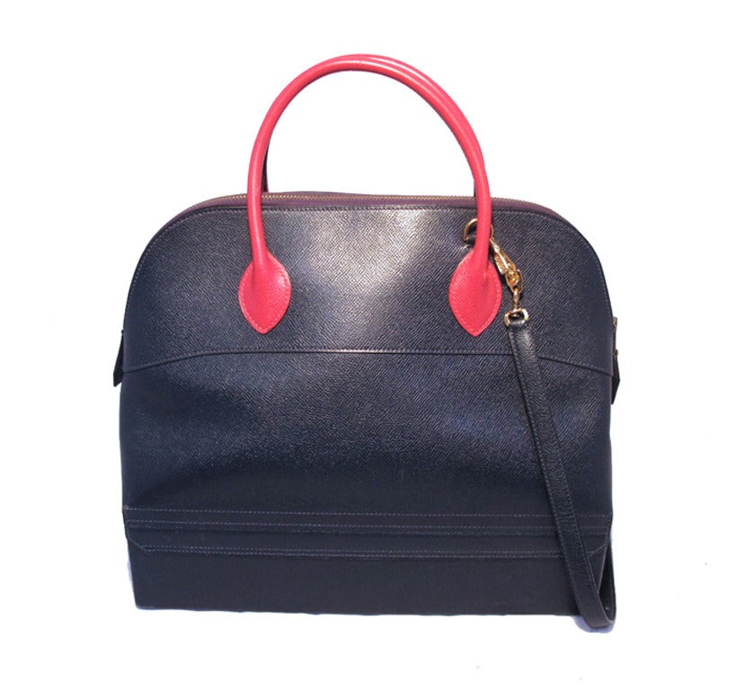 AUTHENTIC HERMES vintage macpherson bolide bag in very good condition.  Navy blue and red courchevel leather trimmed with shining gold hardware.  Top zipper closure opens to a magnificent red leather lined interior that holds 1 zippered and 1 slit