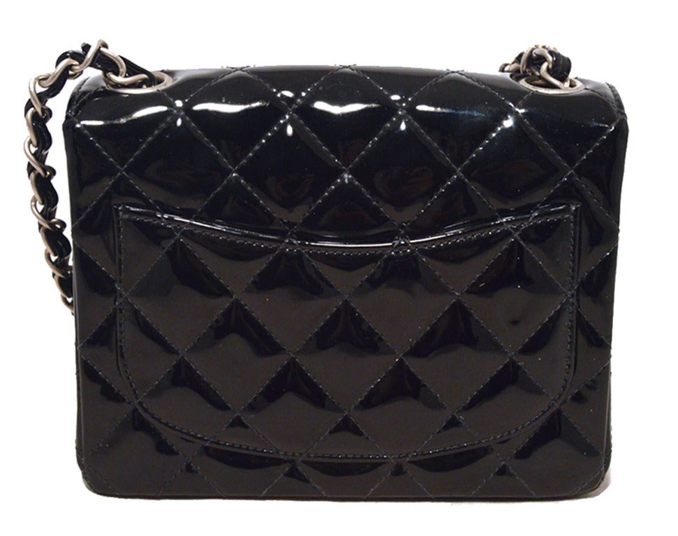 AUTHENTIC CHANEL black patent leather mini classic flap in very good condition.  Quilted black patent leather exterior trimmed with matte silver hardware and the signature woven chain and leather shoulder strap.  Single flap style CC twist closure