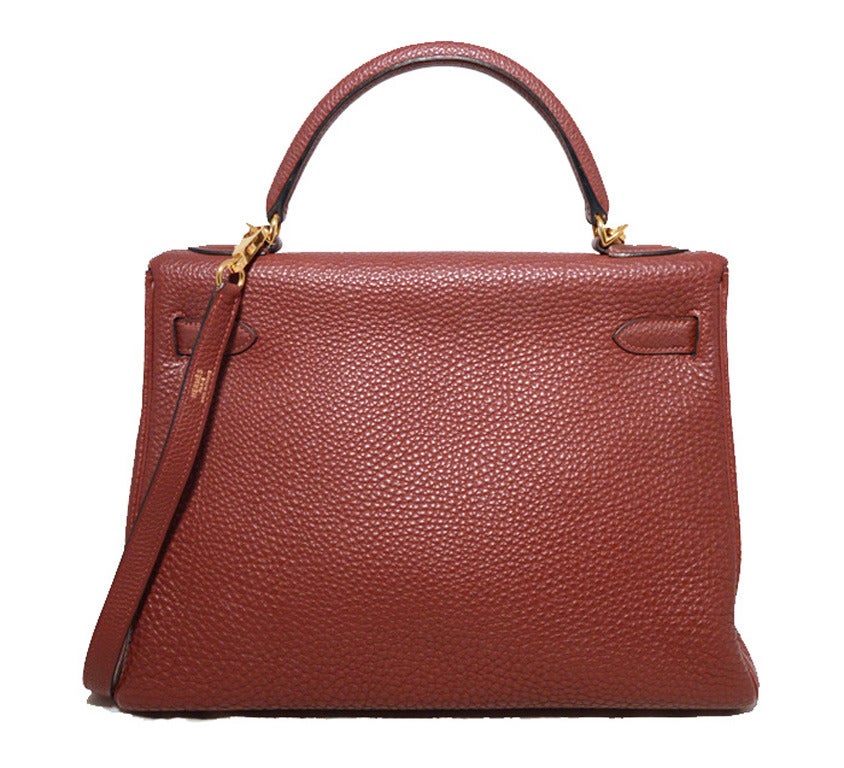 STUNNING HERMES ruby rouge 32cm kelly bag in very good condition.  Rouge garance togo leather exterior trimmed with shining gold hardware.  Signature twist, double strap flap closure opens to a matching leather lined interior that holds 1 side