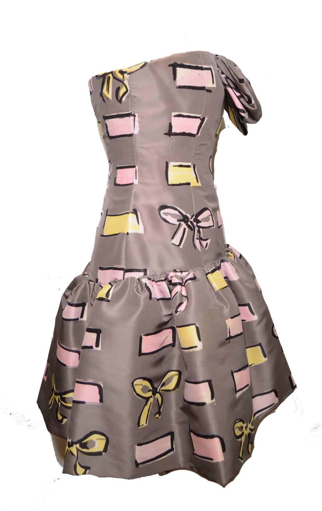 Grey silk taffeta with unique block and bow print in yellow and pink with black outline.  Large front bow at bust. Pencil skirt with ruffle skirt overlay.  14.5