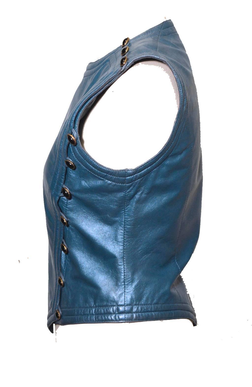 Amazing vintage Ungaro 1980s blue leather vest. 100% genuine leather in beautiful blue coloring that has a subtle shimmer to it. 3 gold and black buttons on top right shoulder and 7 more along the right side from bust to hem. Fully lined with blue
