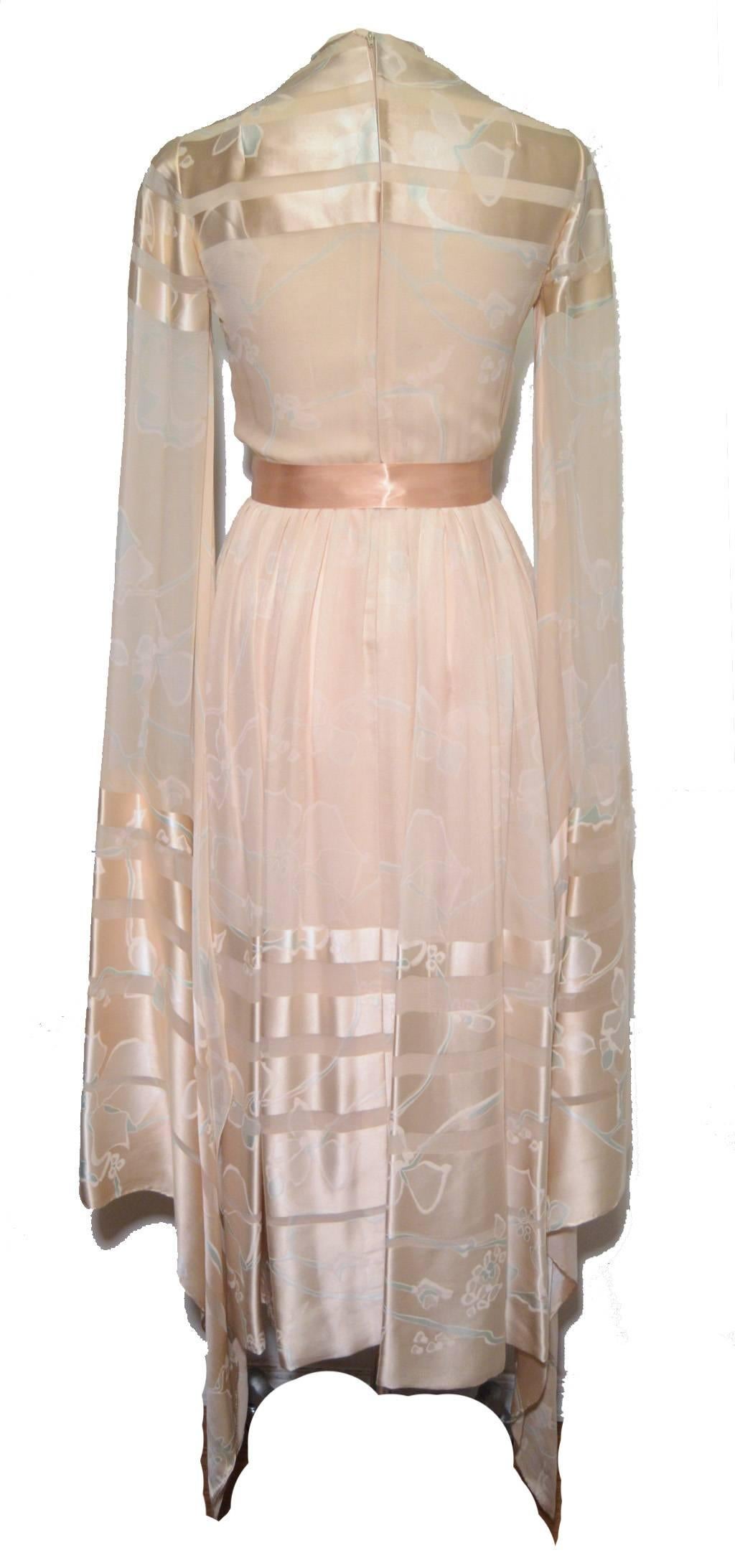 Stunning silk butterfly sleeve dress c1980s by Bill Blass.  Nude peach satin and ivory silk chiffon with long dramatic butterfly sleeves and a pale peach satin sash at the waist. Unlined sheer striped chiffon and satin top with sheer chiffon sleeves