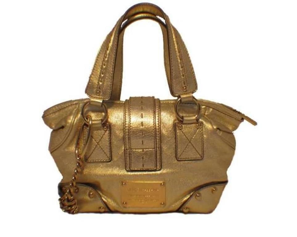 This adorable Dolce and Gabbana bag adds the perfect touch of shine to any wardrobe. The exterior is in mint condition featuring light gold leather trimmed with gold hardware. The solid push latch closure provides security for your belongings inside
