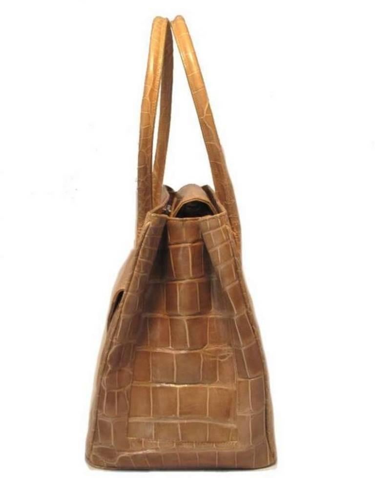 This fabulous Alexandra Knight handbag is in excellent condition. The exterior features stunning tan alligator skin with comfortably double handles and a front flap pocket. The top snap flap closure opens to 2 storage compartments separated by a