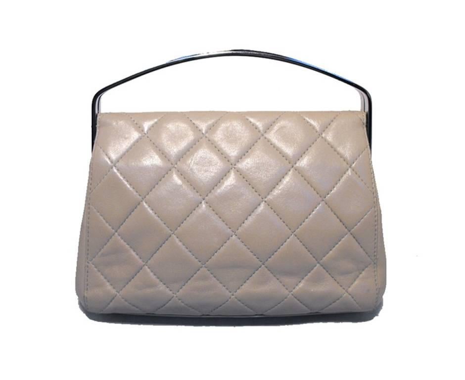 This beautiful Chanel handbag is in excellent condition. The exterior features gorgeous quilted beige leather trimmed with silver hardware. The hinge closure opens to a matching beige leather lined interior that holds one side zippered pocket and