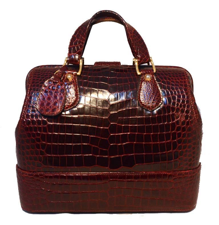 Amazing Rare Gucci alligator doctor bag in very good condition.  Dark red alligator leather exterior trimmed with gold hardware.  Double handles with matching alligator luggage tag included. Sliding latch strap closure with dial lock.  Hinged
