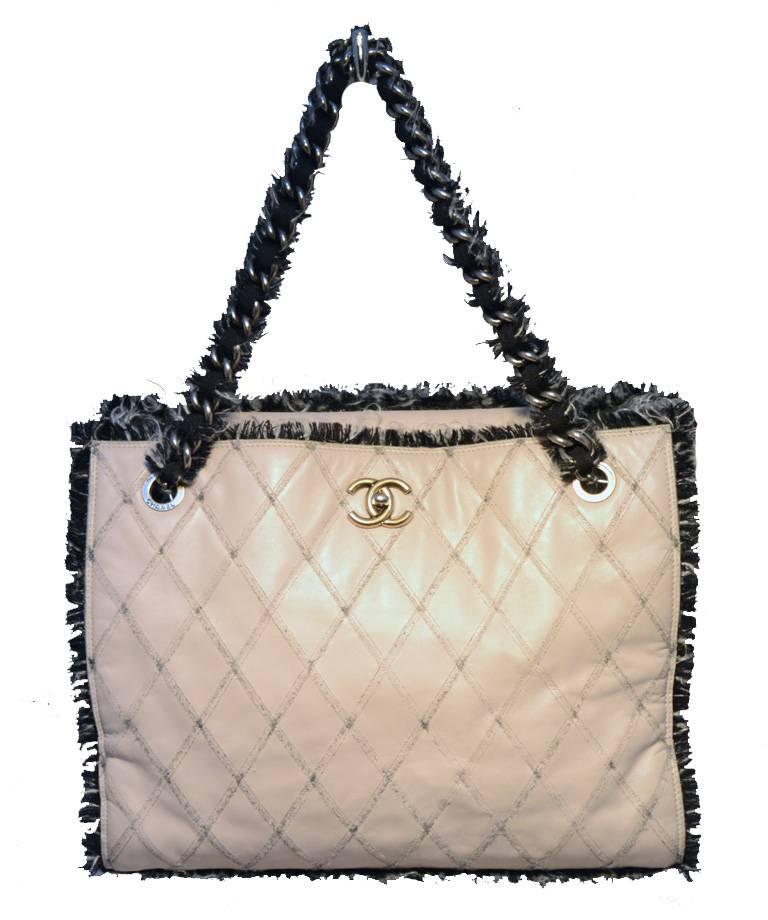 Gorgeous Chanel leather and tweed tote bag in excellent condition.  Light grey quilted leather exterior trimmed with mixed black, white, and grey wool tweed edges.  Antiqued gold and gunmetal hardware. Woven chain and canvas double shoulder straps
