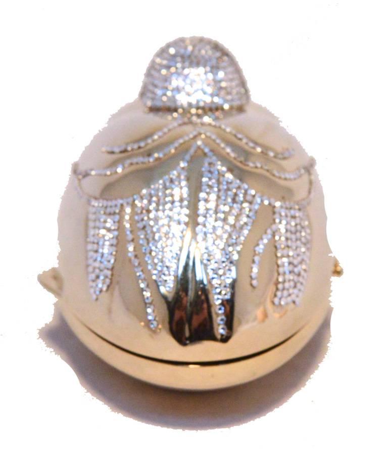 Beautiful Judith Leiber sitting duck minaudiere in very good vintage condition.  Gold sitting duck form with clear Swarovski crystal embellishments around the exterior. Side lifting closure opens to a gold leather lined interior that holds one side