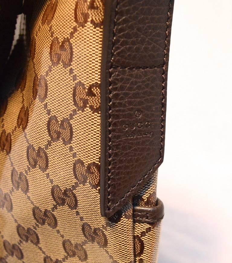 Perfect Gucci shoulder bag in excellent condition.  Coated monogram canvas trimmed with brown leather and brown woven nylon adjustable shoulder strap.  Front side slit pocket. Top zipper closure opens to a brown nylon lined interior that holds 1