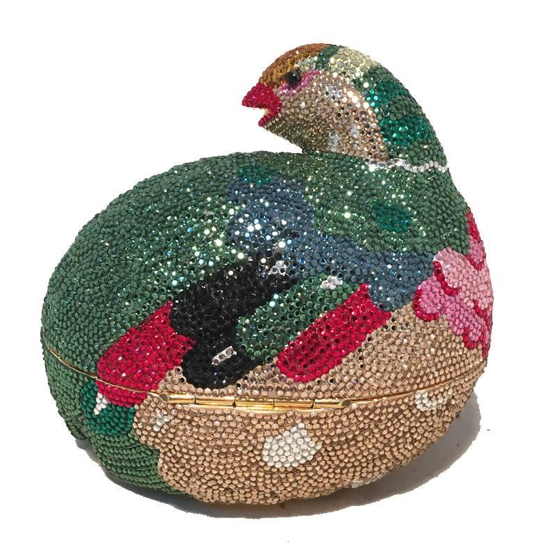 Beautiful Judith Leiber colorful Quail minaudiere in excellent condition.  Gorgeous Swarovski crystals in gold, green, red, black, pink, and white surround the exterior of this piece.  Front push closure opens to a gold leather lined interior that