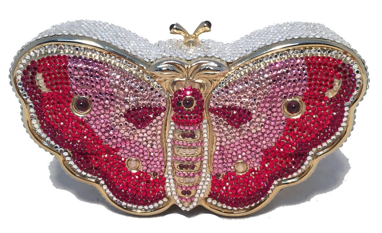 Judith Leiber Swarovski Crystal butterfly minaudiere in excellent condition.  Various pinks and clear crystals surround the exterior of this butterfly shaped piece.  Top latch closure opens to a gold leather lined interior that holds an attached