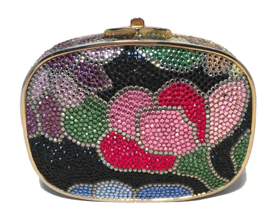 Beautiful Judith Leiber black floral box minaudiere in excellent condition.  Multicolor swarovski crystal exterior in a floral design over a black background.  Top button closure opens to a gold leather lined interior that holds an attached hidden