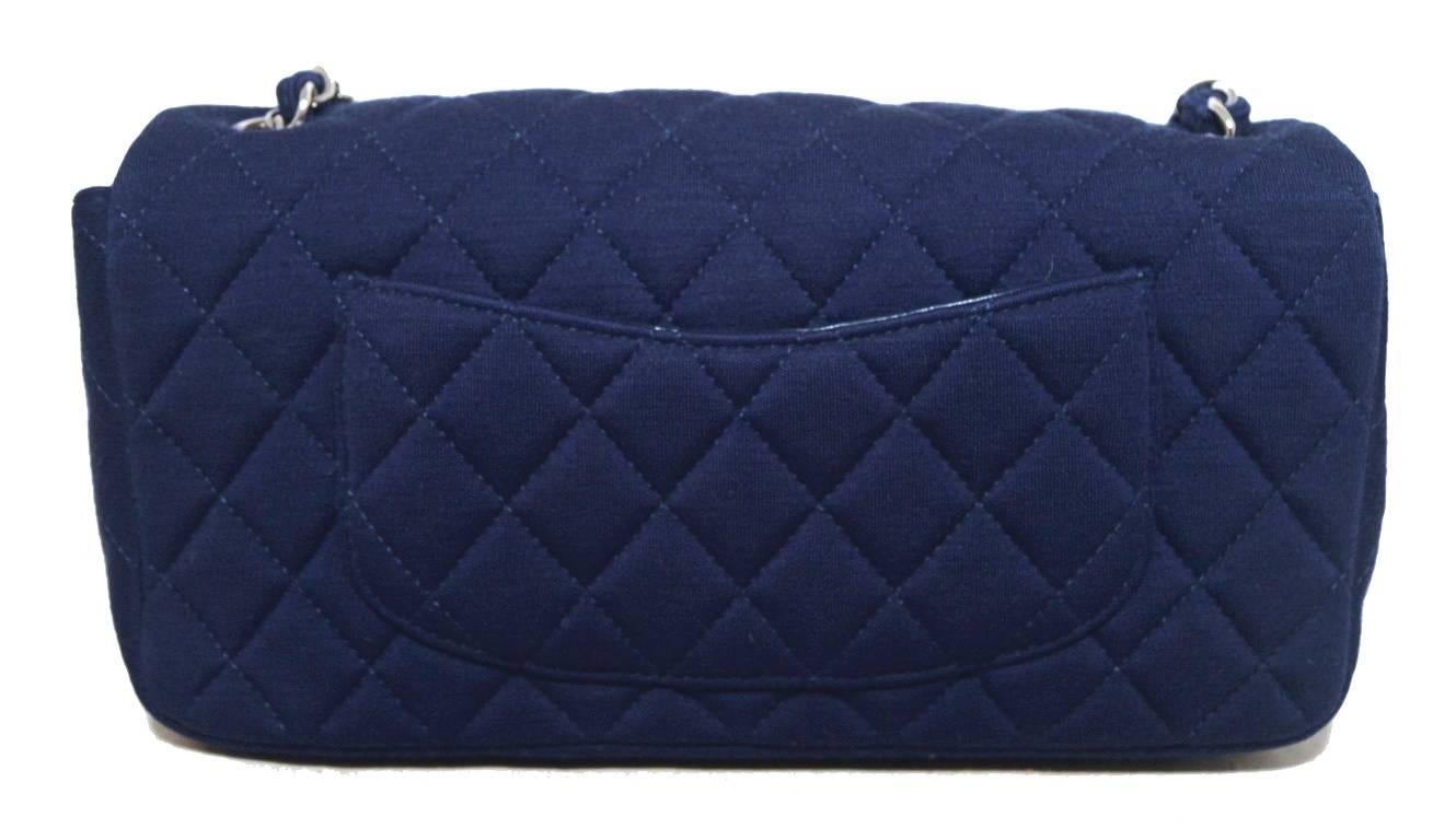 Limited Edition Chanel Navy blue quilted cotton classic in excellent condition. Navy blue diamond quilted cotton exterior trimmed with silver hardware and the signature woven chain and cotton shoulder strap. Front twist cc closure opens single flap