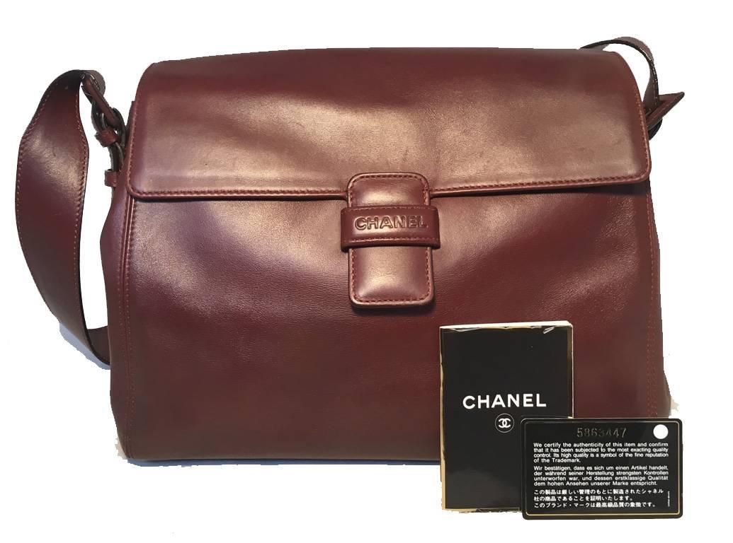 Gorgeous Chanel leather flap shoulder bag in excellent condition.  Maroon leather with buckled side shoulder strap details.  Front loop closure opens single flap style to a brown nylon lined interior. Two separate storage compartments keep your