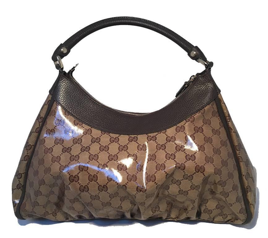 BEAUTIFUL GUCCI monogram shoulder bag with buckle in excellent condition. Coated Monogram canvas exterior trimmed with brown leather and gold hardware. Top zipper closure opens to a brown canvas lined interior that holds 1 zippered side pocket. This