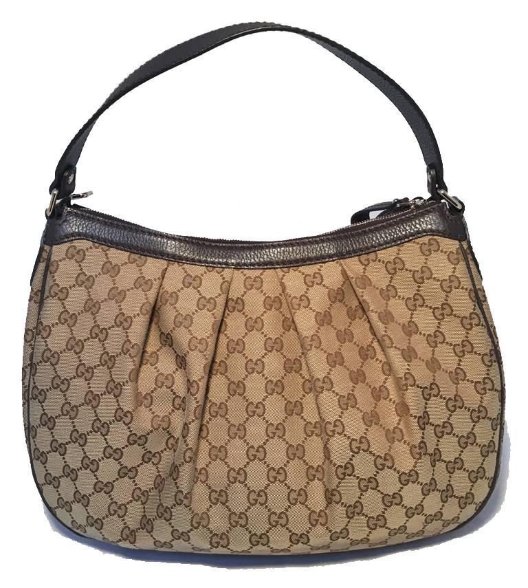 Timeless GUCCI monogram canvas shoulder bag in excellent condition.  Signature monogram canvas exterior trimmed with brown leather and gold hardware.  Top zipper closure opens to a brown woven cotton lined interior that holds 1 side zippered pocket.