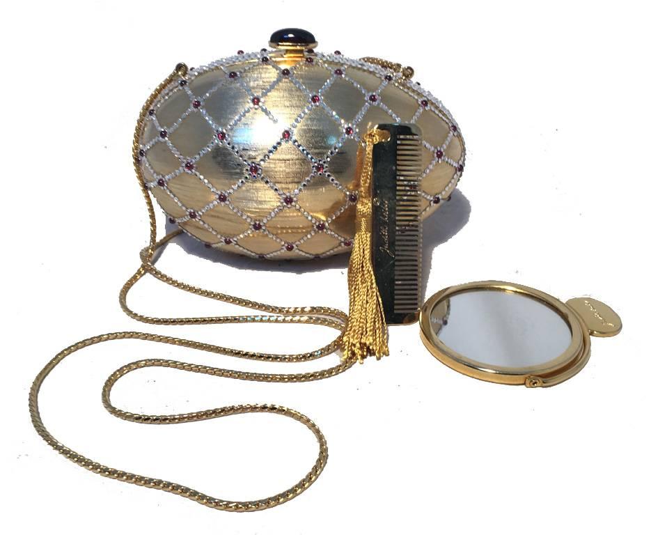 Beautiful Judith Leiber vintage egg minaudiere in excellent condition.  Gold egg adorned with silver swarovski crystals in a cross-hatch pattern with delicate dark red gemstones throughout.  Top button closure opens to a gold leather lined interior