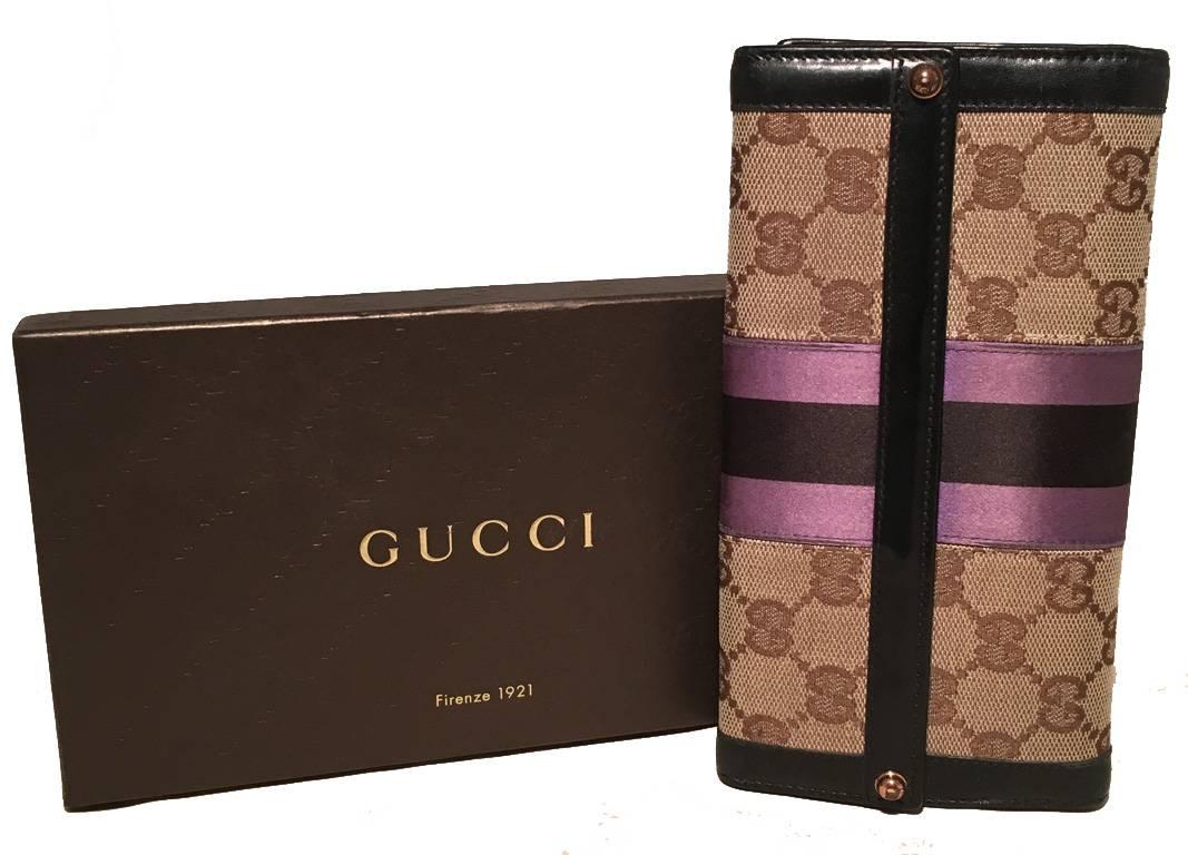 GORGEOUS Vintage Gucci monogram wallet in excellent condition.  Monogram canvas exterior trimmed with black leather and purple and black striped satin detail. Snap closure opens to a black leather interior that holds plenty of credit card slots, and